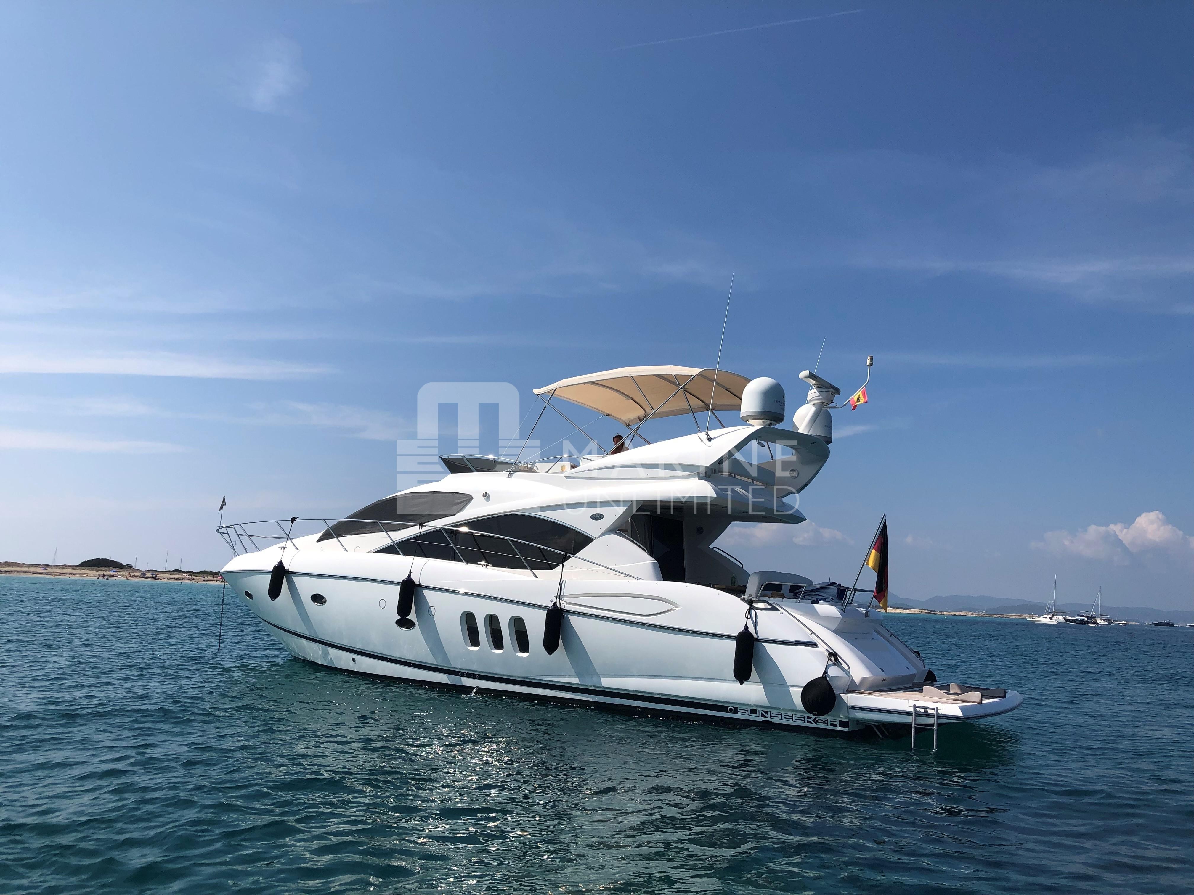 2010 Sunseeker Manhattan 52 yacht on calm blue waters under clear sky.
