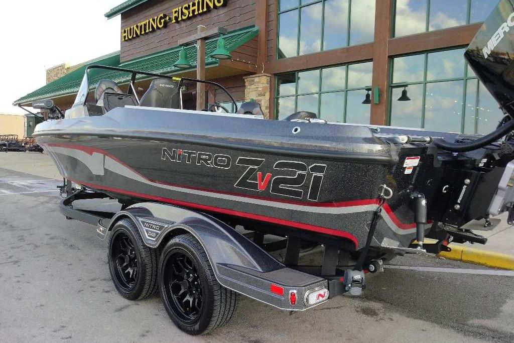 2024 Nitro ZV21 Pro fishing boat parked outside a hunting and fishing store.