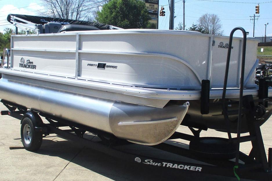 2026 Sun Tracker Party Barge 18 DLX pontoon boat on trailer, parked outdoors.