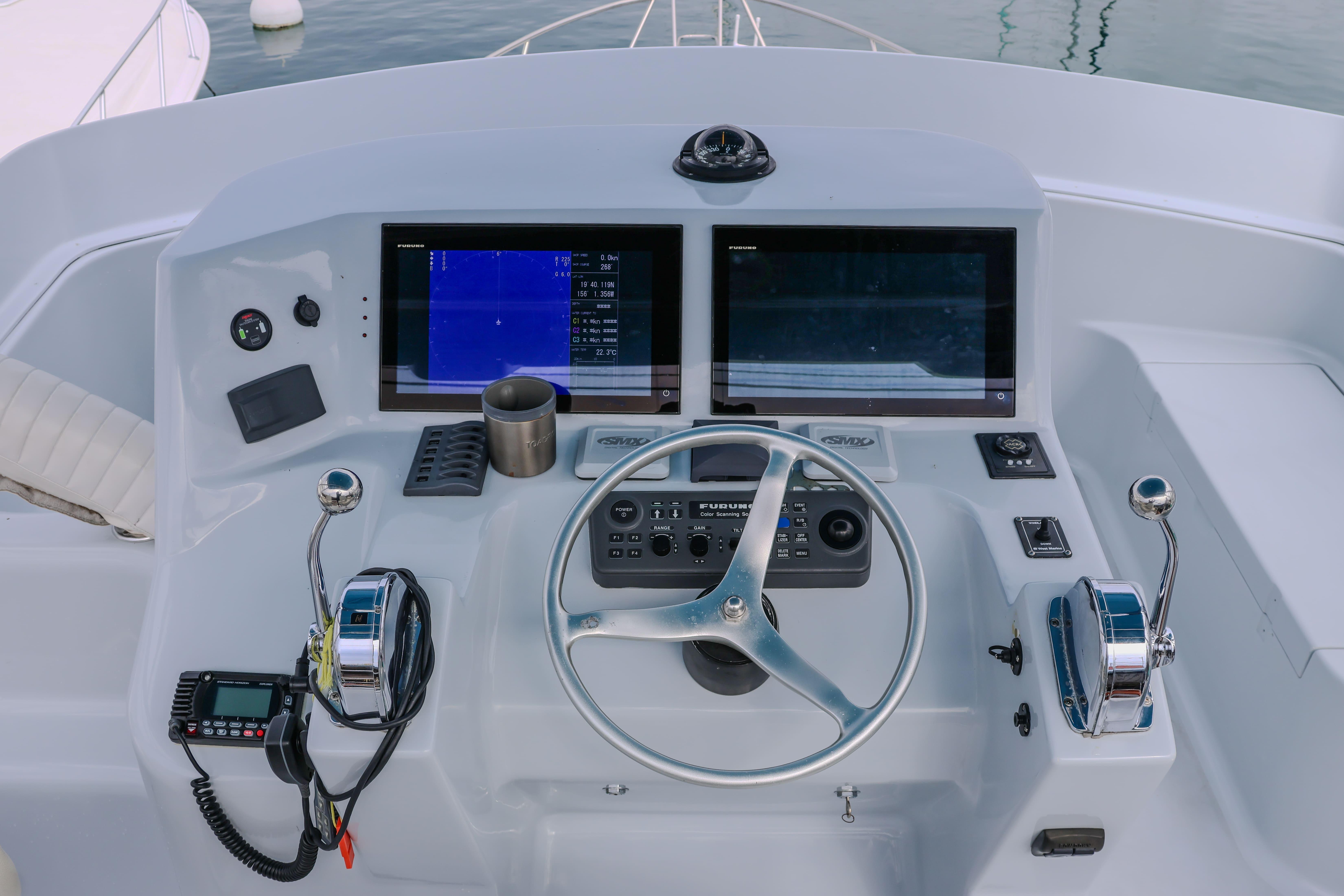 Helm of 2001 Black Watch 40 boat with dual screens and steering wheel.