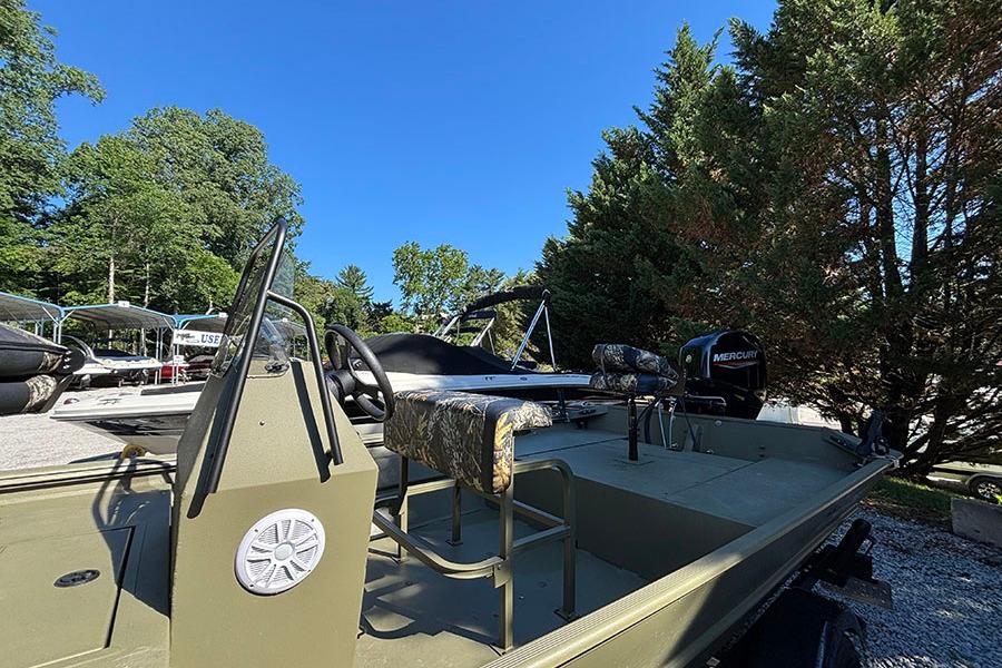 2022 Lowe Roughneck 1660 boat with Mercury engine, parked outdoors under clear blue sky.