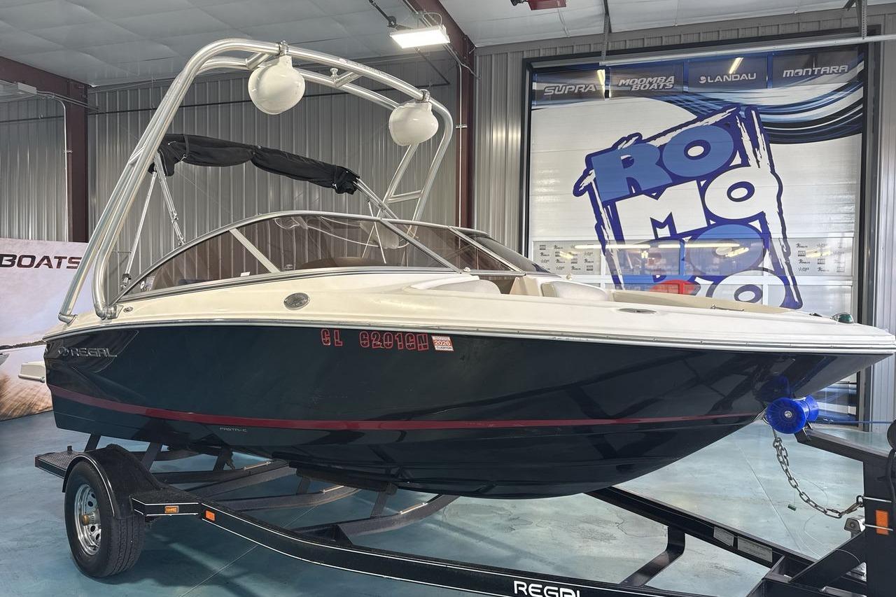 2012 Regal 1900 Bowrider boat on trailer in showroom setting.