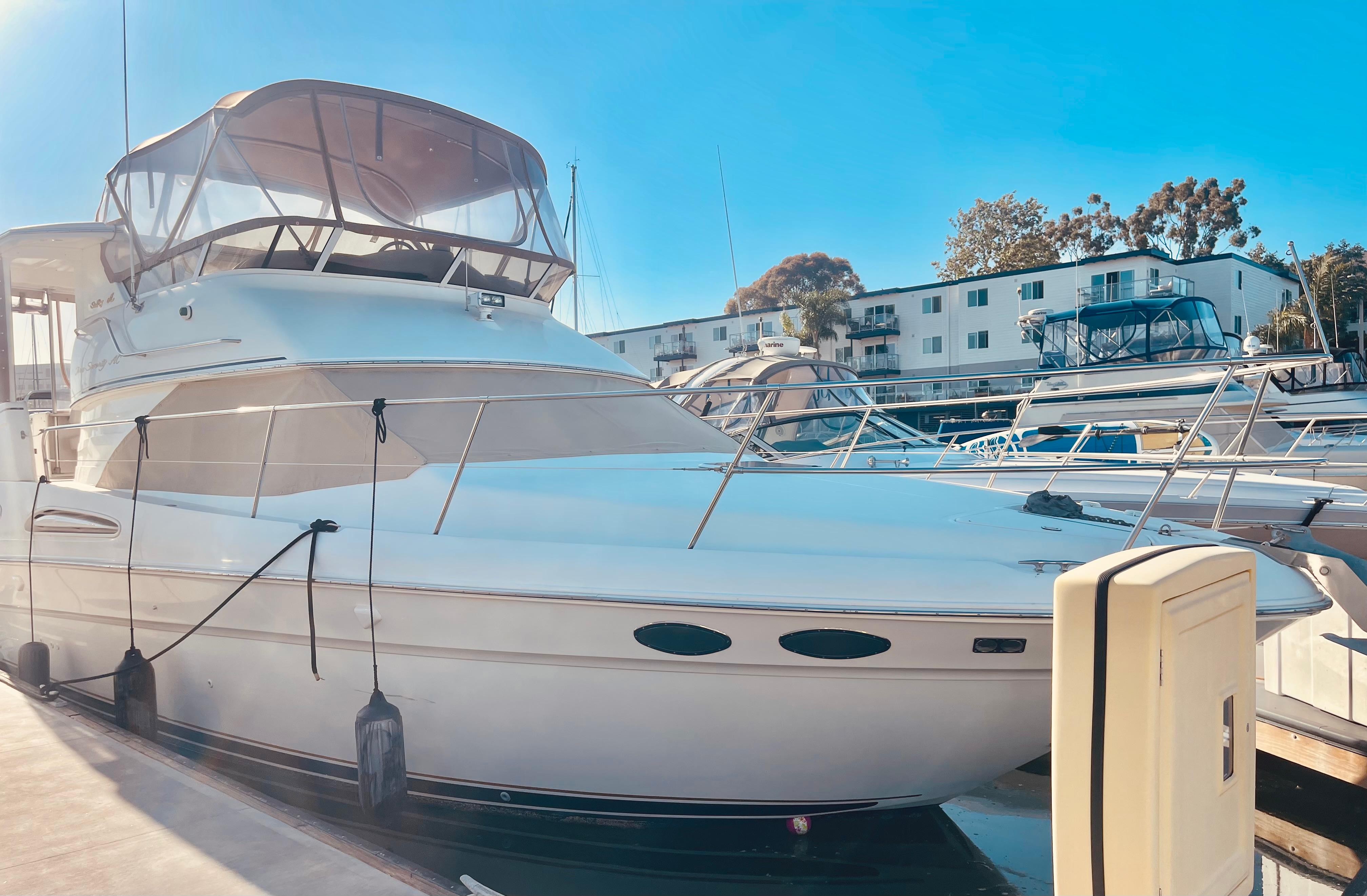 1998 Sea Ray 370 Aft Cabin yacht docked at marina under clear blue sky.