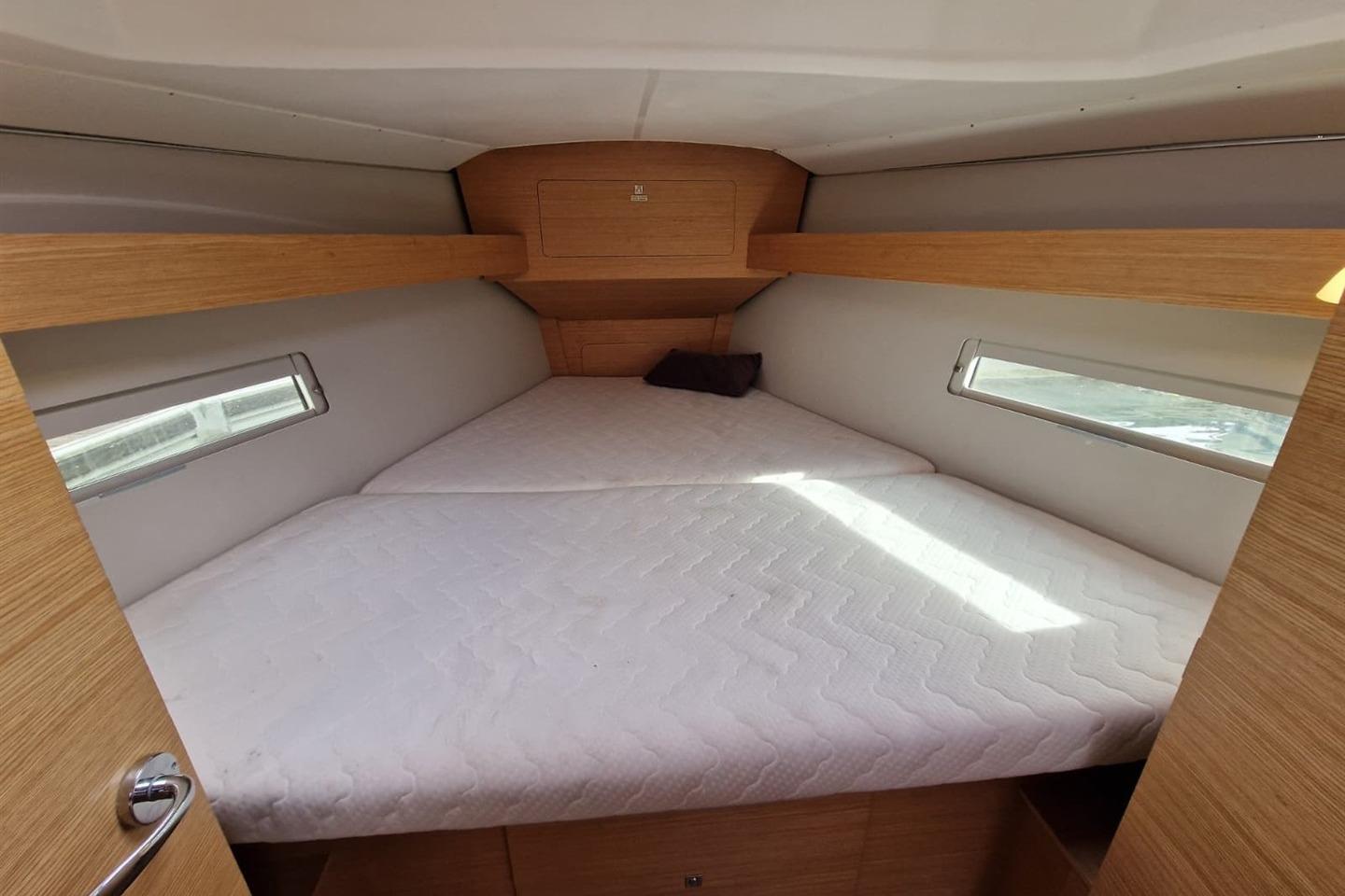 2018 Dufour 382 Grand Large cabin with cozy bed and wooden interior.