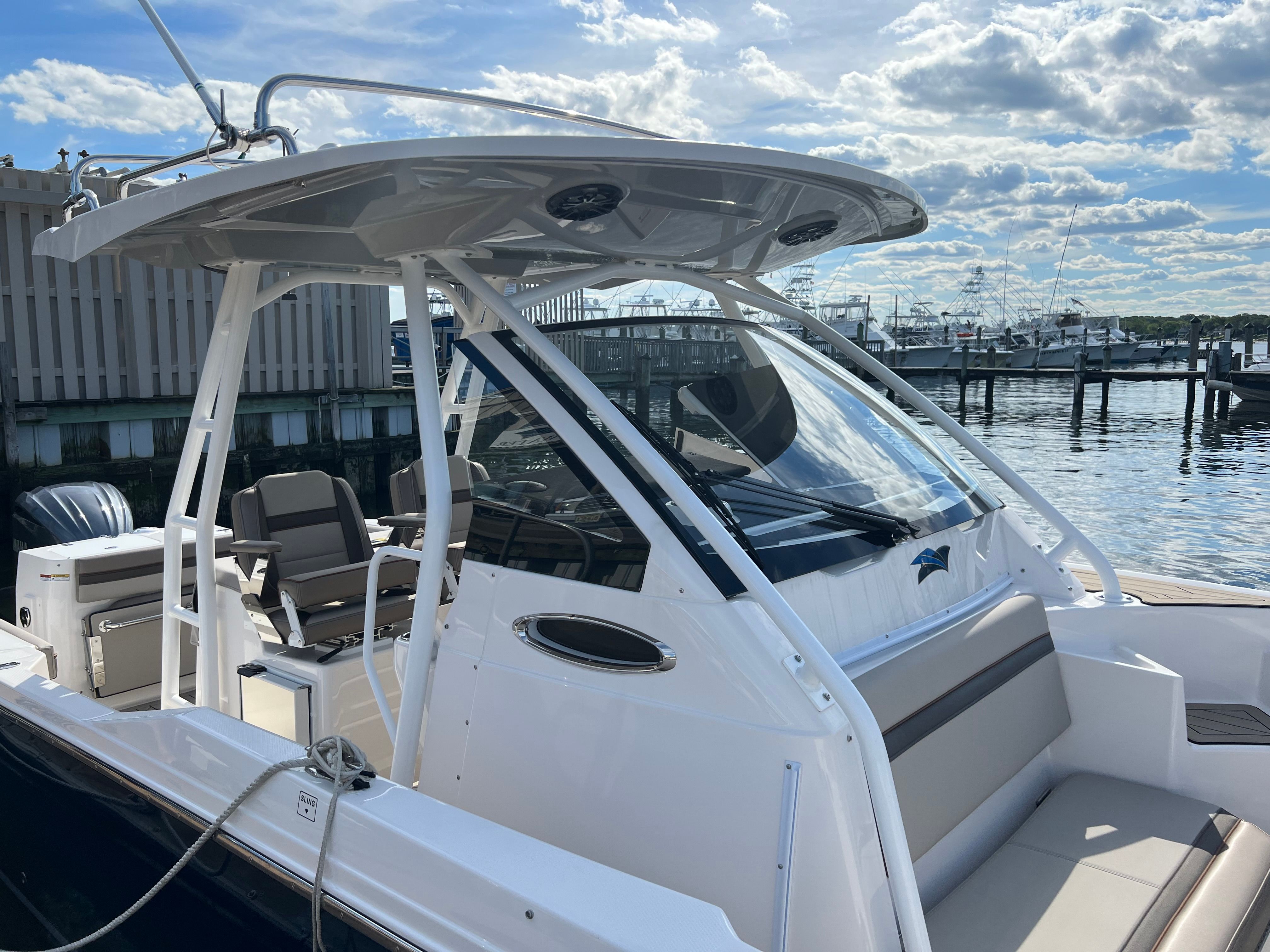 A 2022 Cutwater C-24 CW boat docked. It features a sleek design with a protective hardtop.