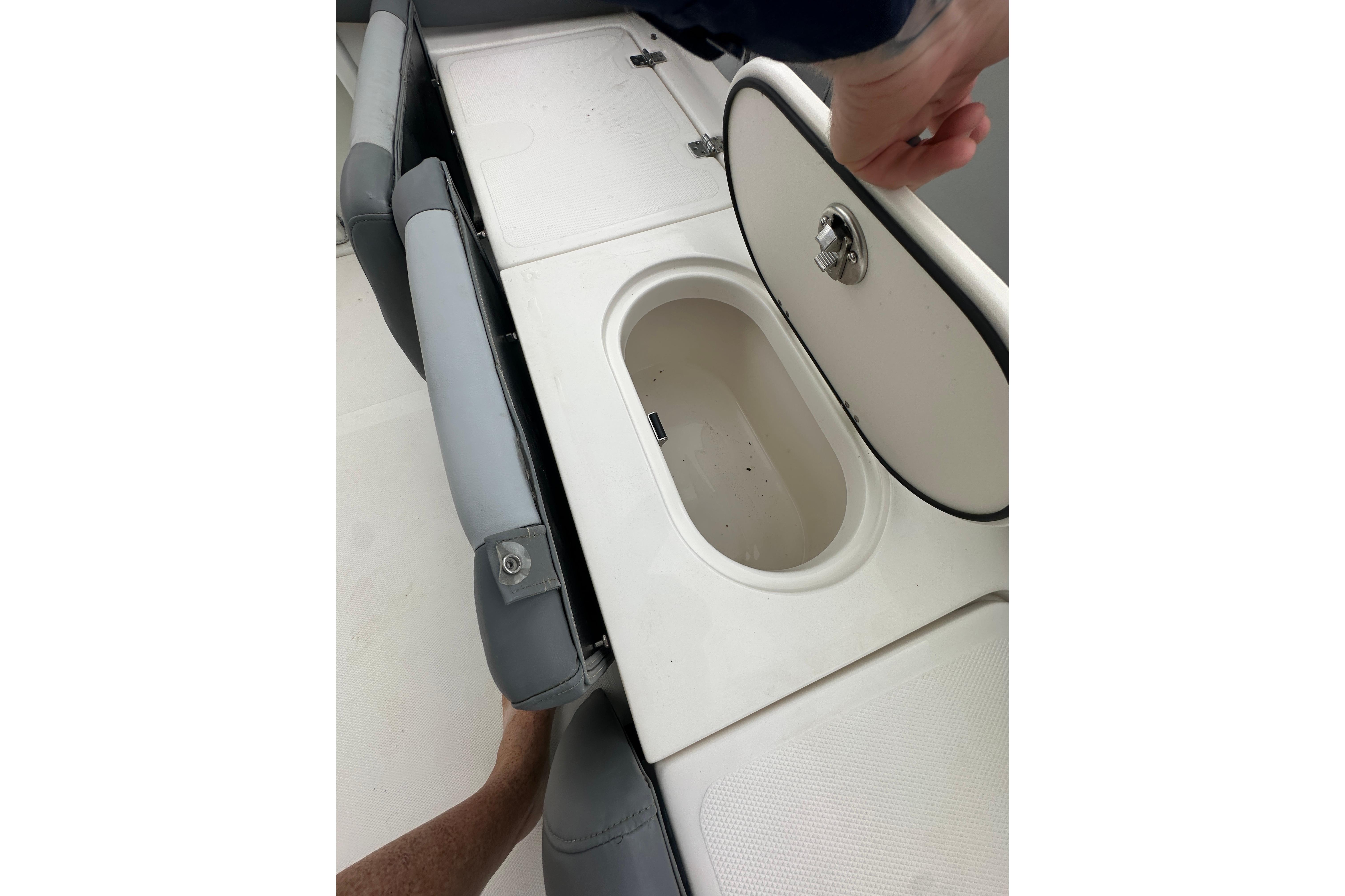 2023 NauticStar 2102 Legacy boat seat with storage compartment open.