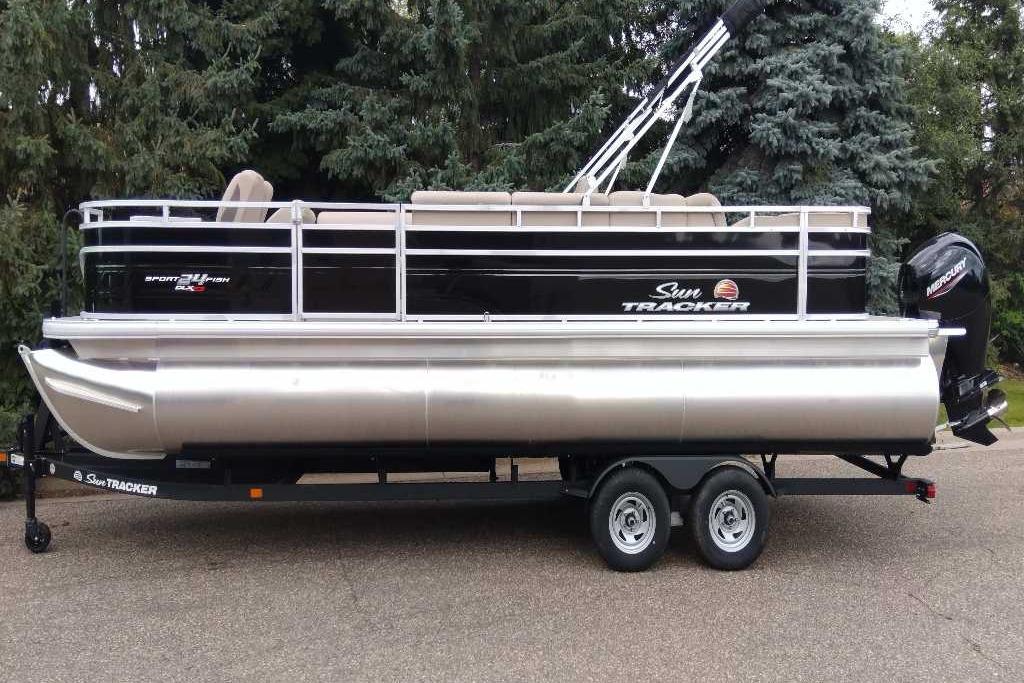 2025 Sun Tracker Sportfish 24 XP3 pontoon boat on trailer, parked outdoors.