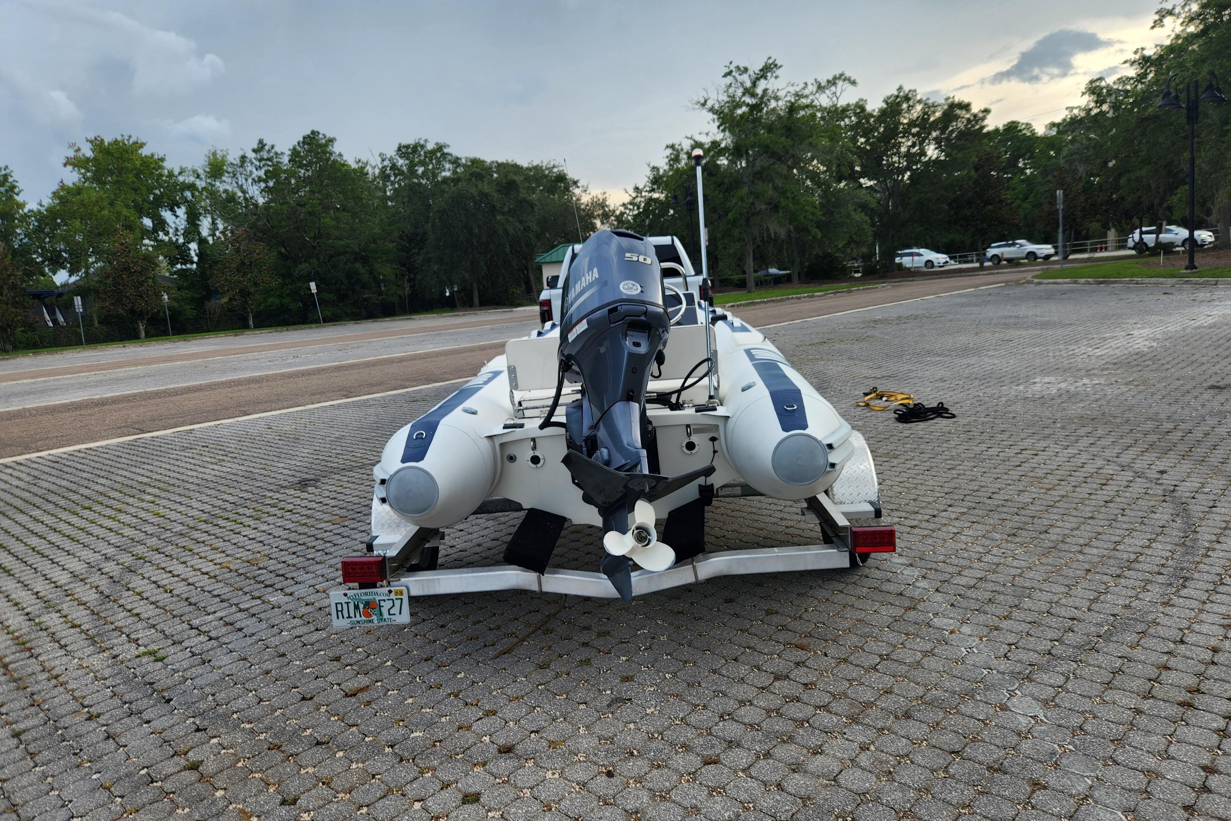 2019 Novurania DL 400 boat on trailer with Yamaha outboard motor in parking lot.