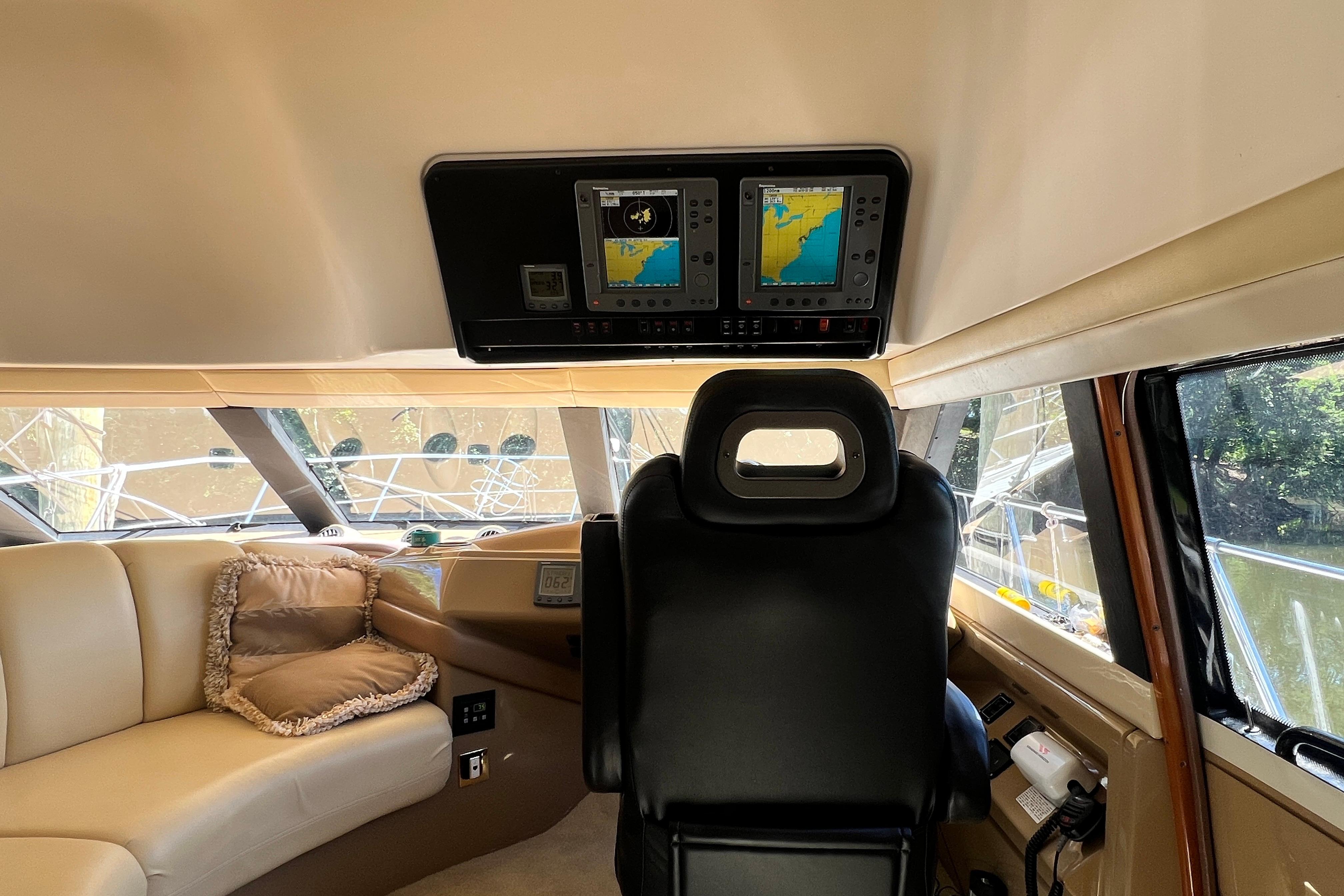 Interior of 2003 Carver 450 Voyager Pilothouse with navigation screens and plush seating.