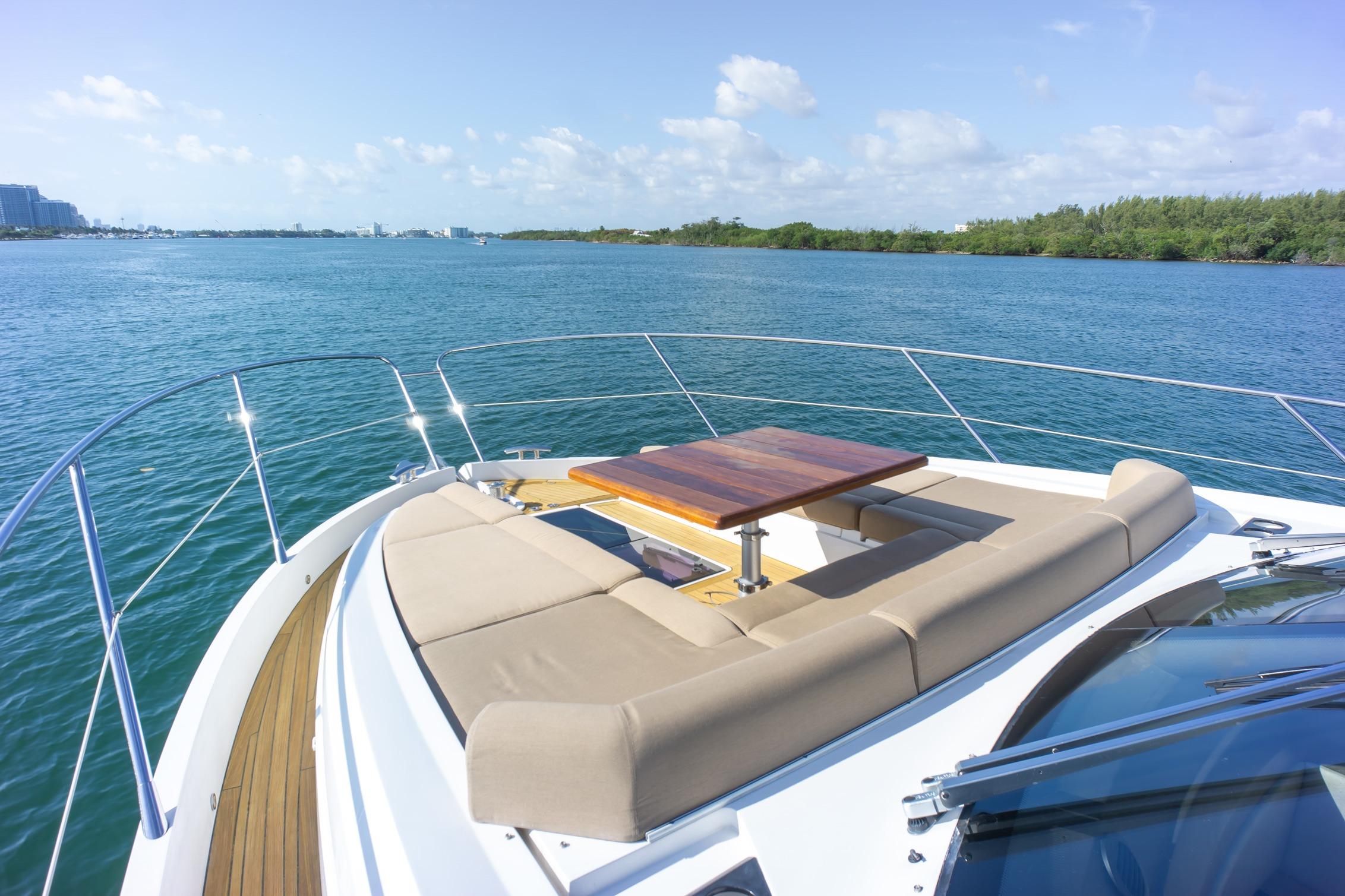Luxurious 2018 Sunseeker Manhattan 52 yacht with elegant deck seating and scenic water view.