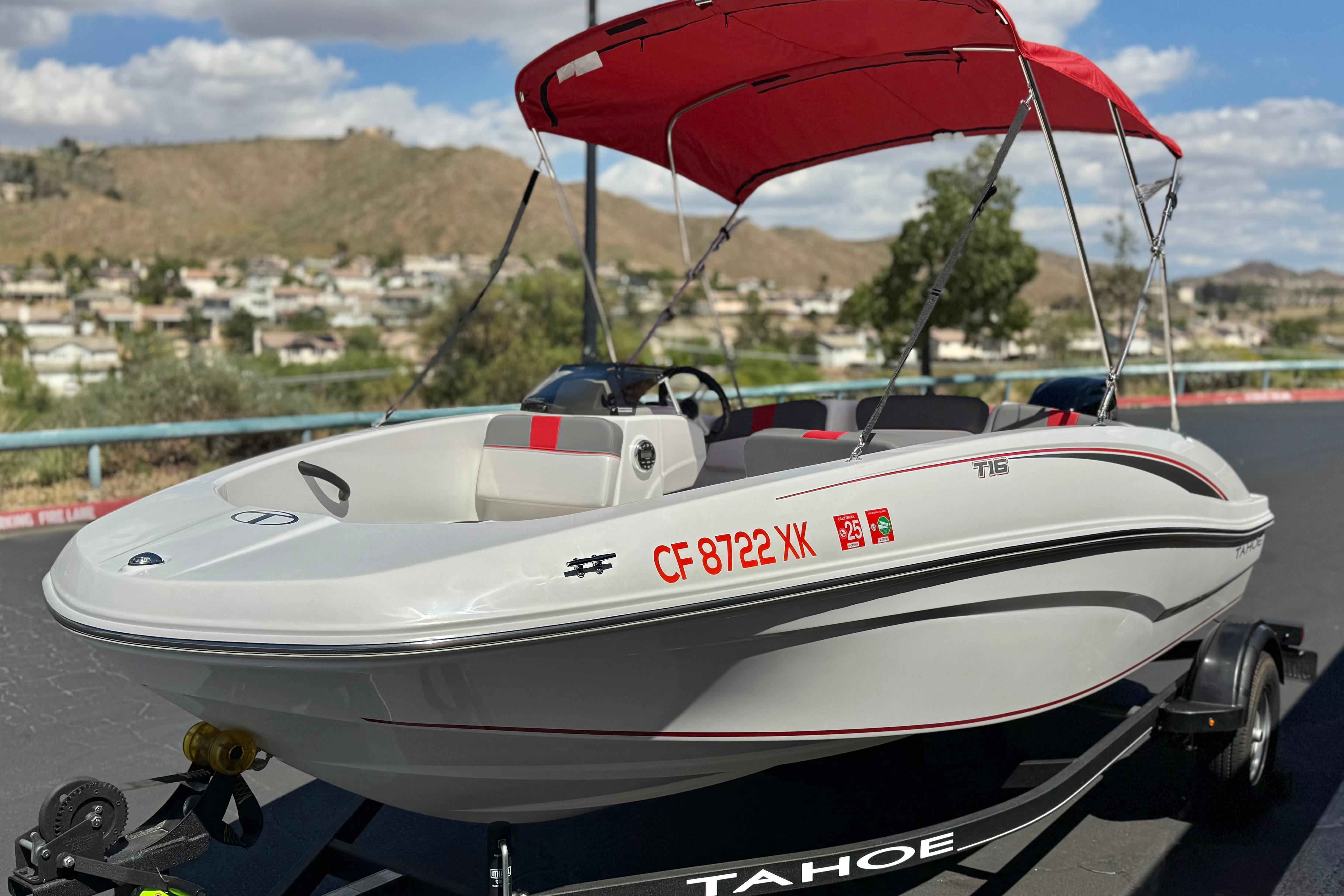2024 Tahoe T16 boat with red canopy on trailer, scenic background.