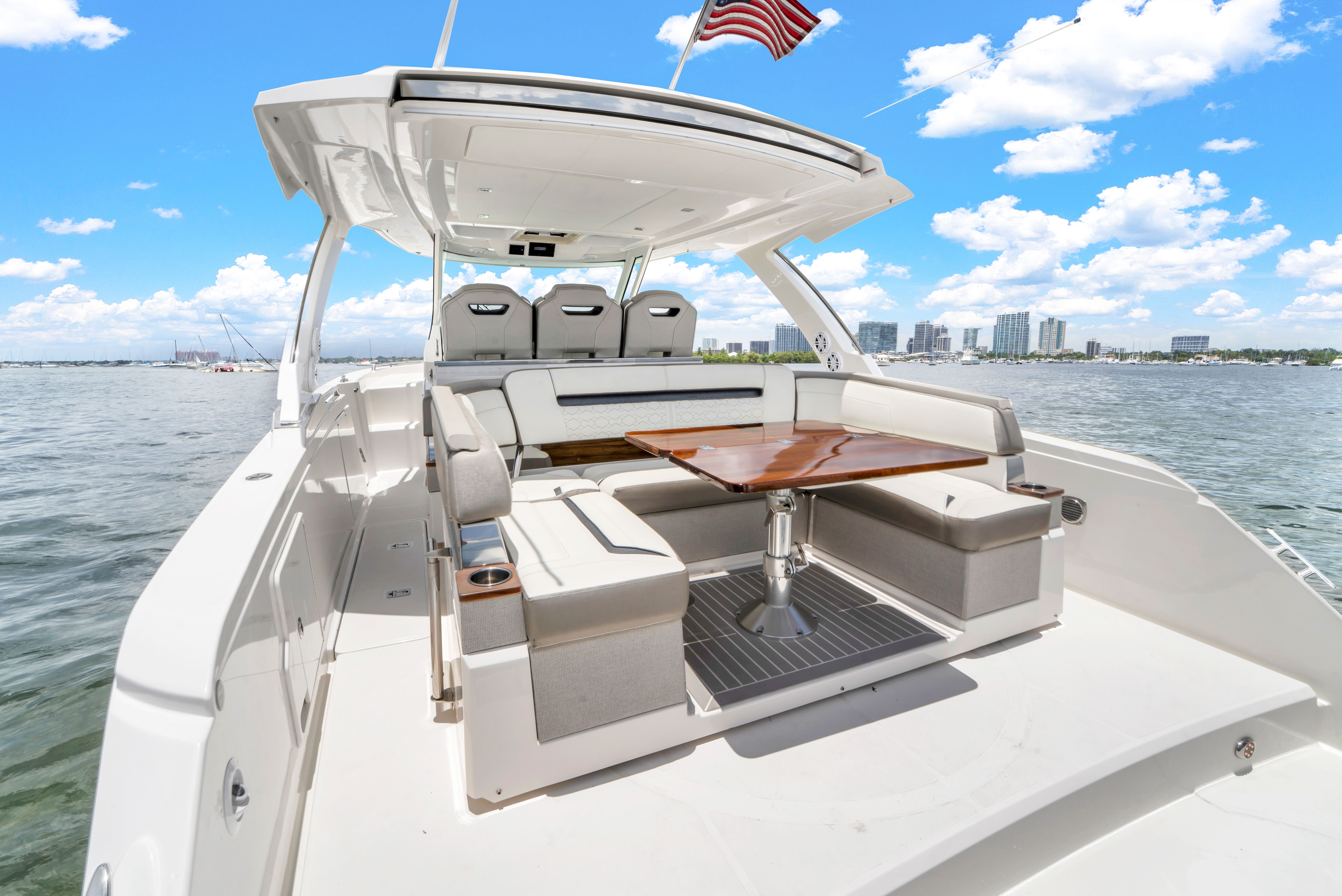 2023 Tiara Yachts 38 LS on the water with a luxurious seating area and table.