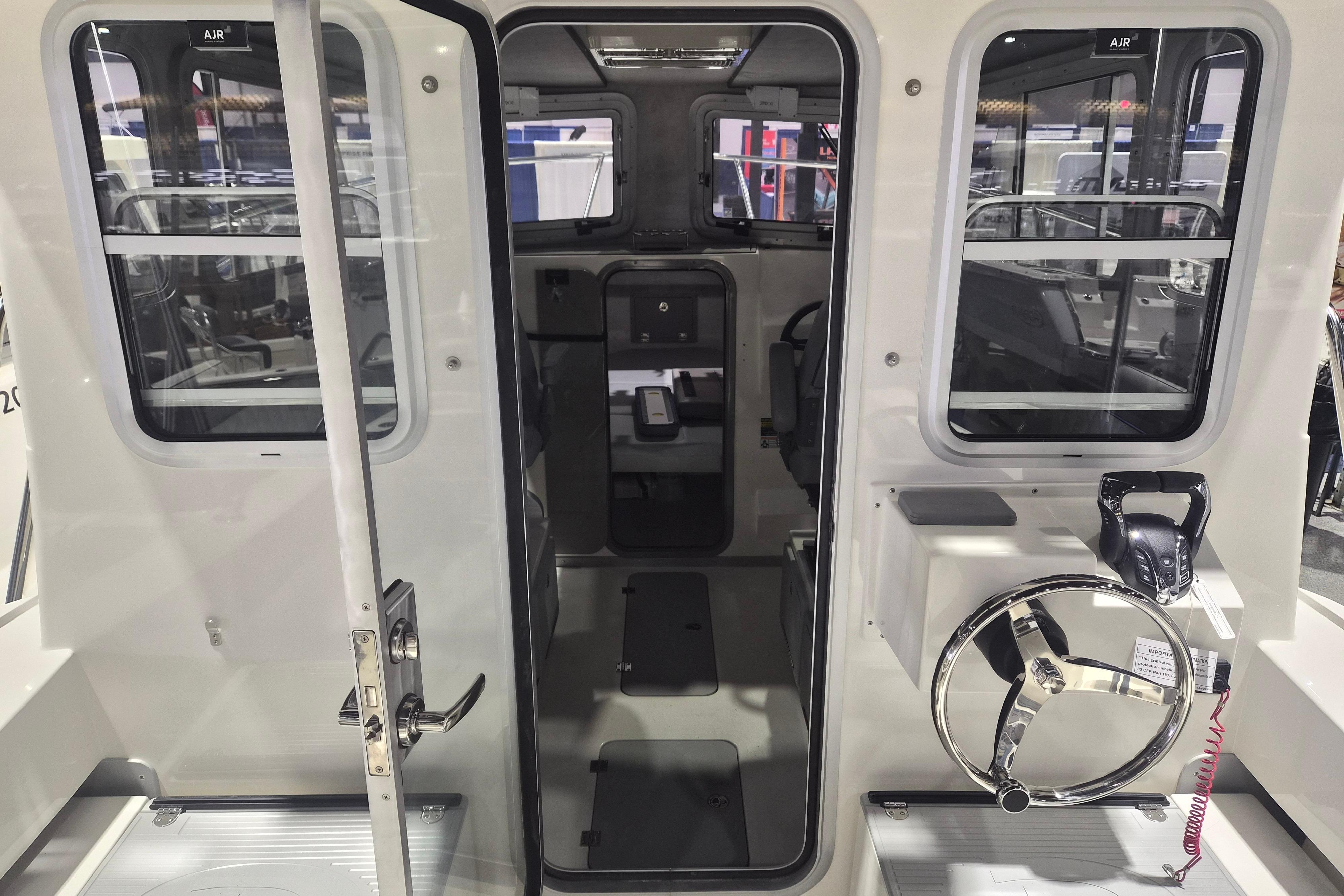 Interior view of 2026 Defiance Admiral 260 EX boat, showcasing helm and cabin entrance.