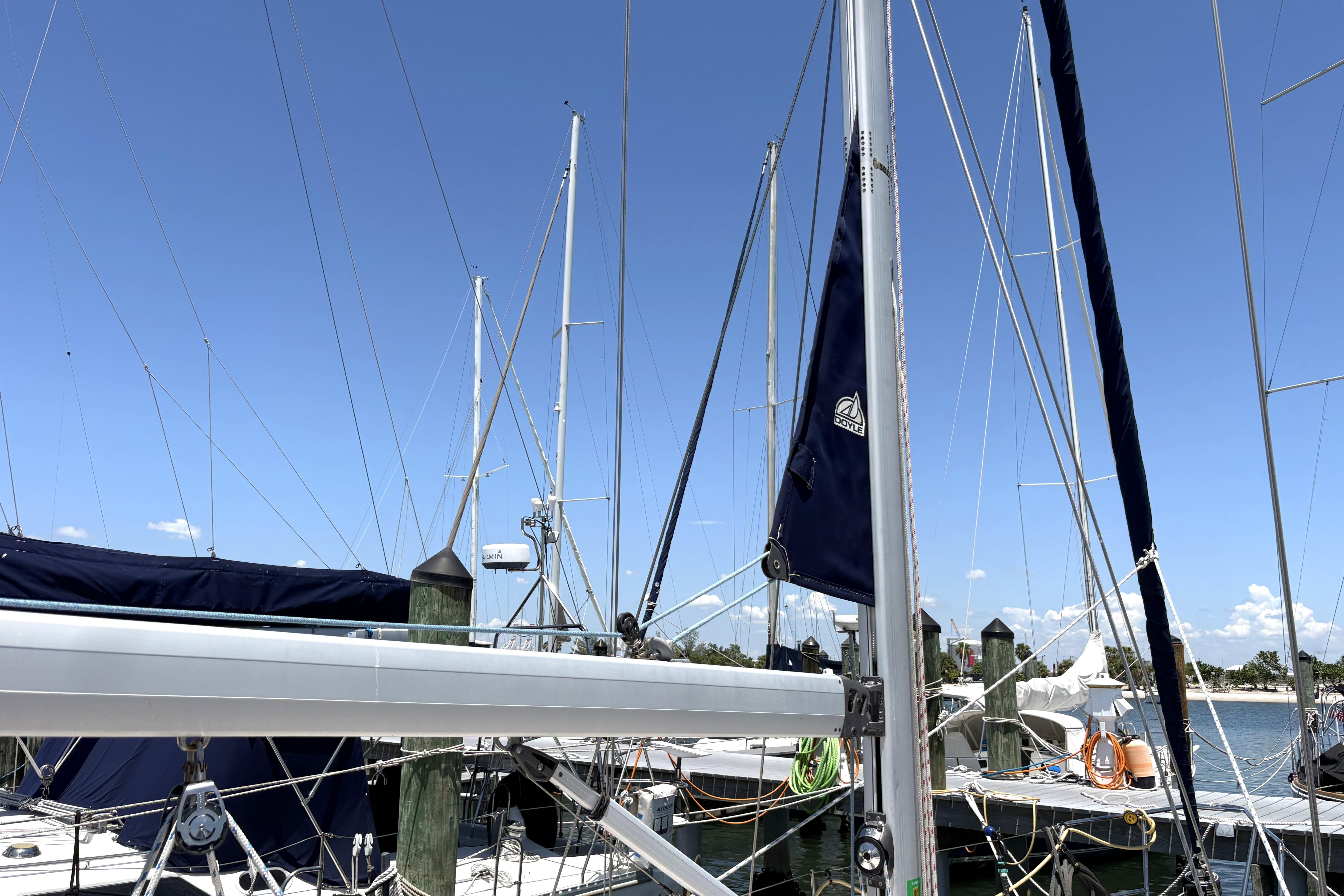 Sailboat mast and rigging of a 2011 Catalina 355 at a marina under clear blue sky.