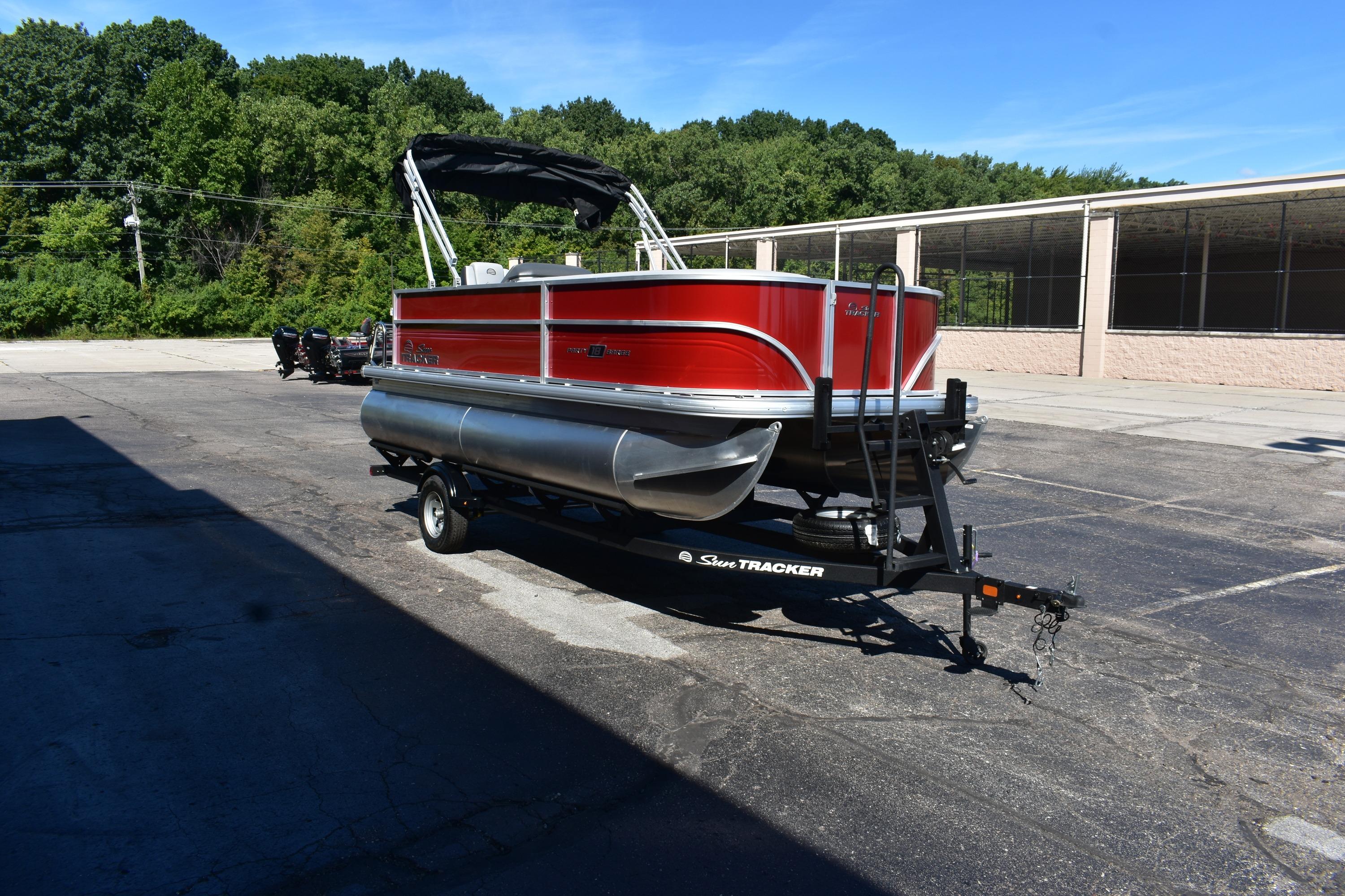 2026 Sun Tracker Party Barge 18 DLX pontoon boat on trailer, parked outdoors.