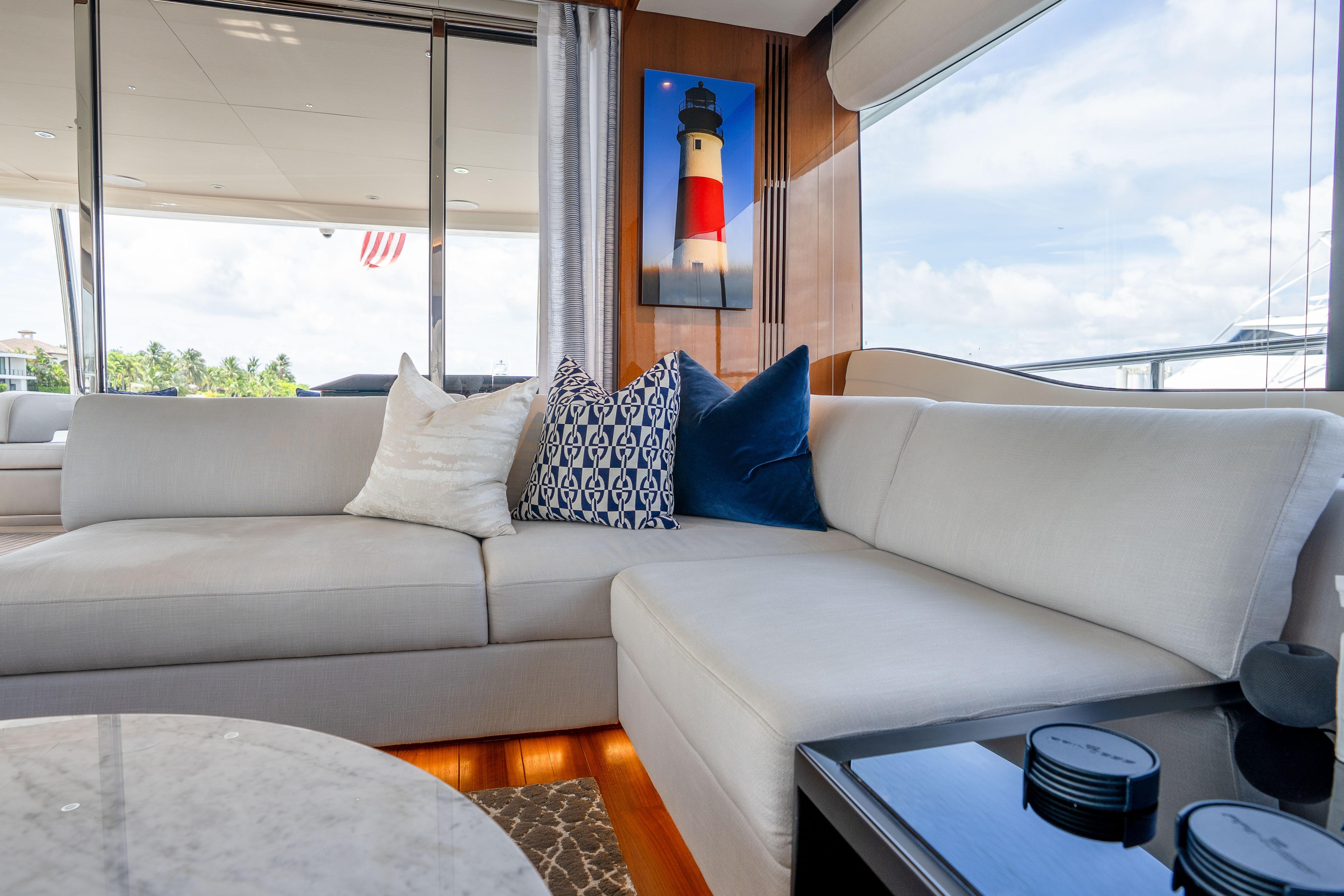 Luxurious interior of 2020 Princess Y85 yacht with elegant sofa and decorative pillows.
