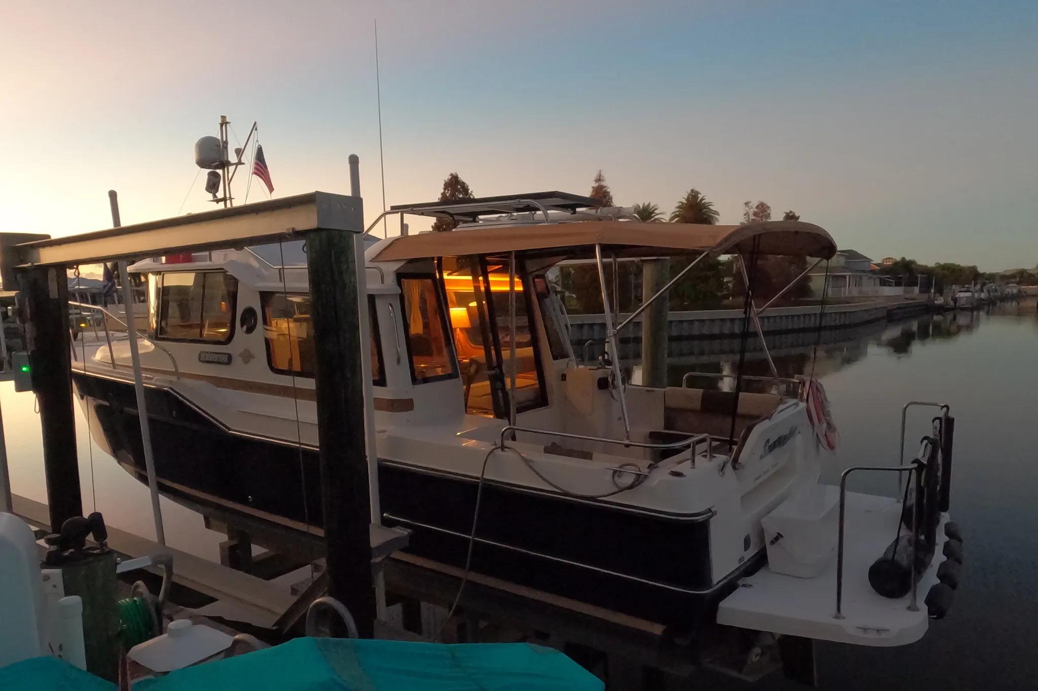 2015 Ranger Tugs R-29 S docked at sunset, with warm interior lighting.