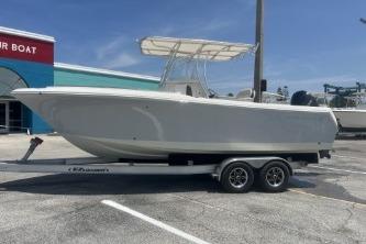 2023 Sailfish 242 CC boat on trailer, parked outdoors under clear sky.