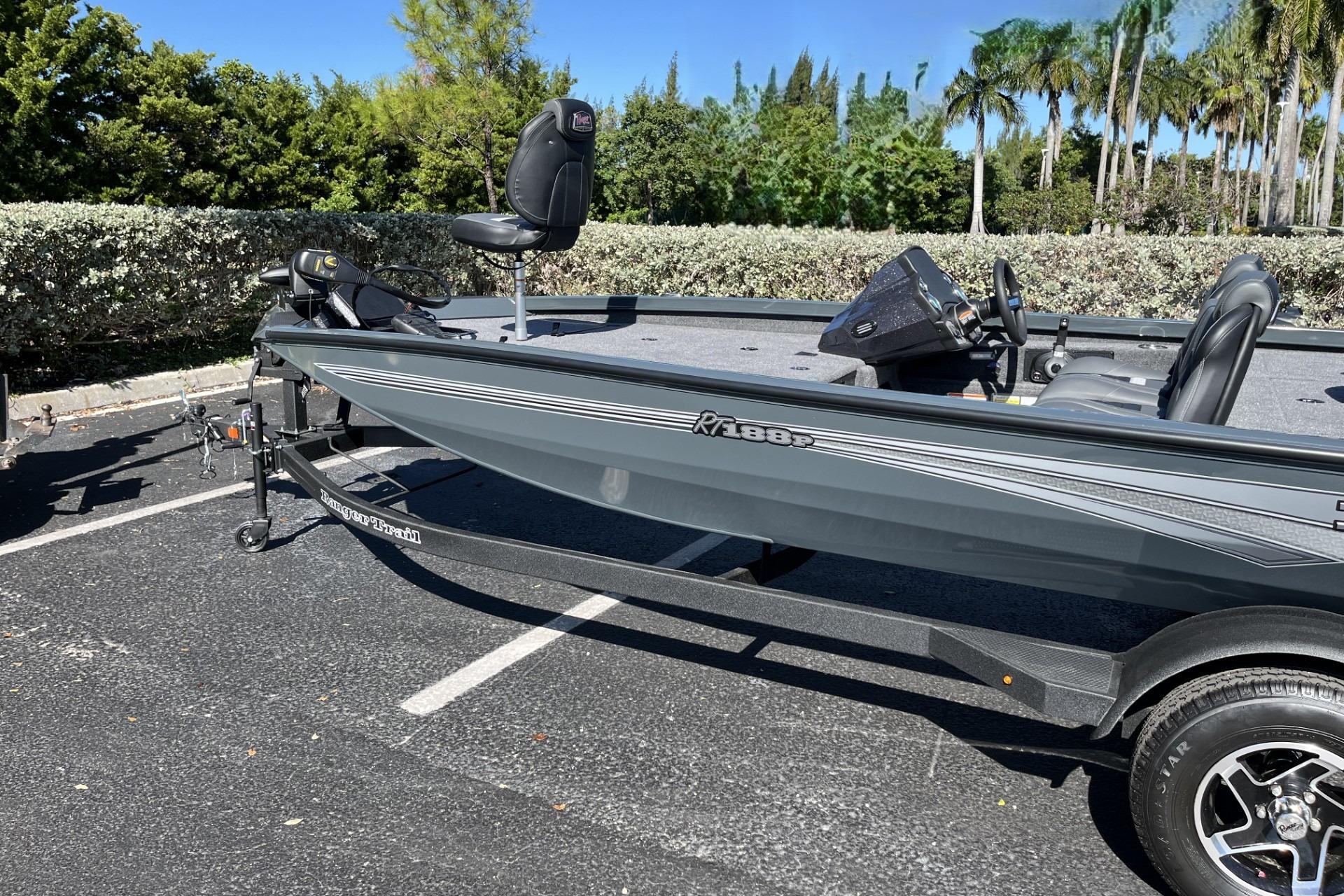 2026 Ranger RT188P boat parked on asphalt, surrounded by greenery.
