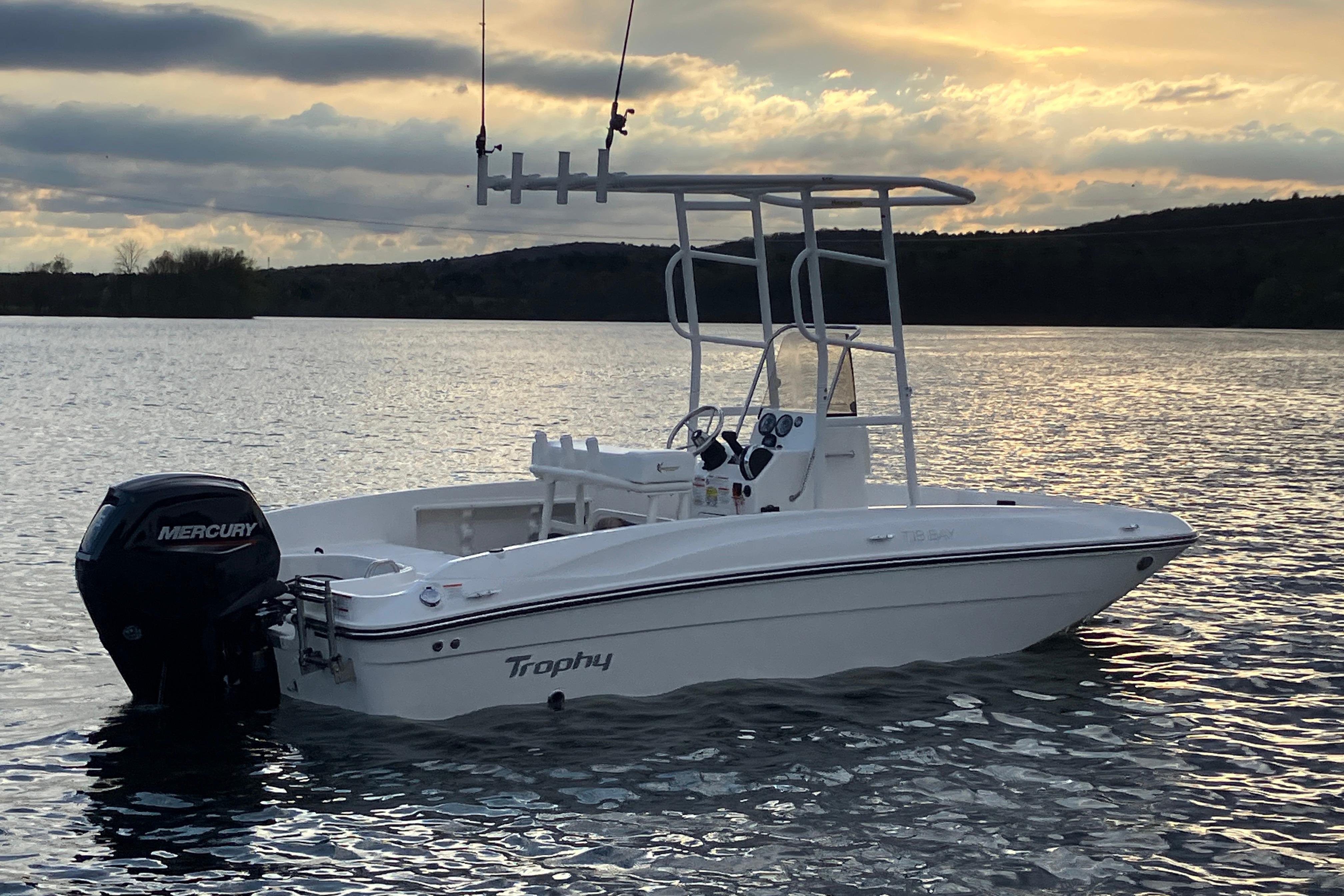 2026 Bayliner Trophy T18 boat on a serene lake at sunset.