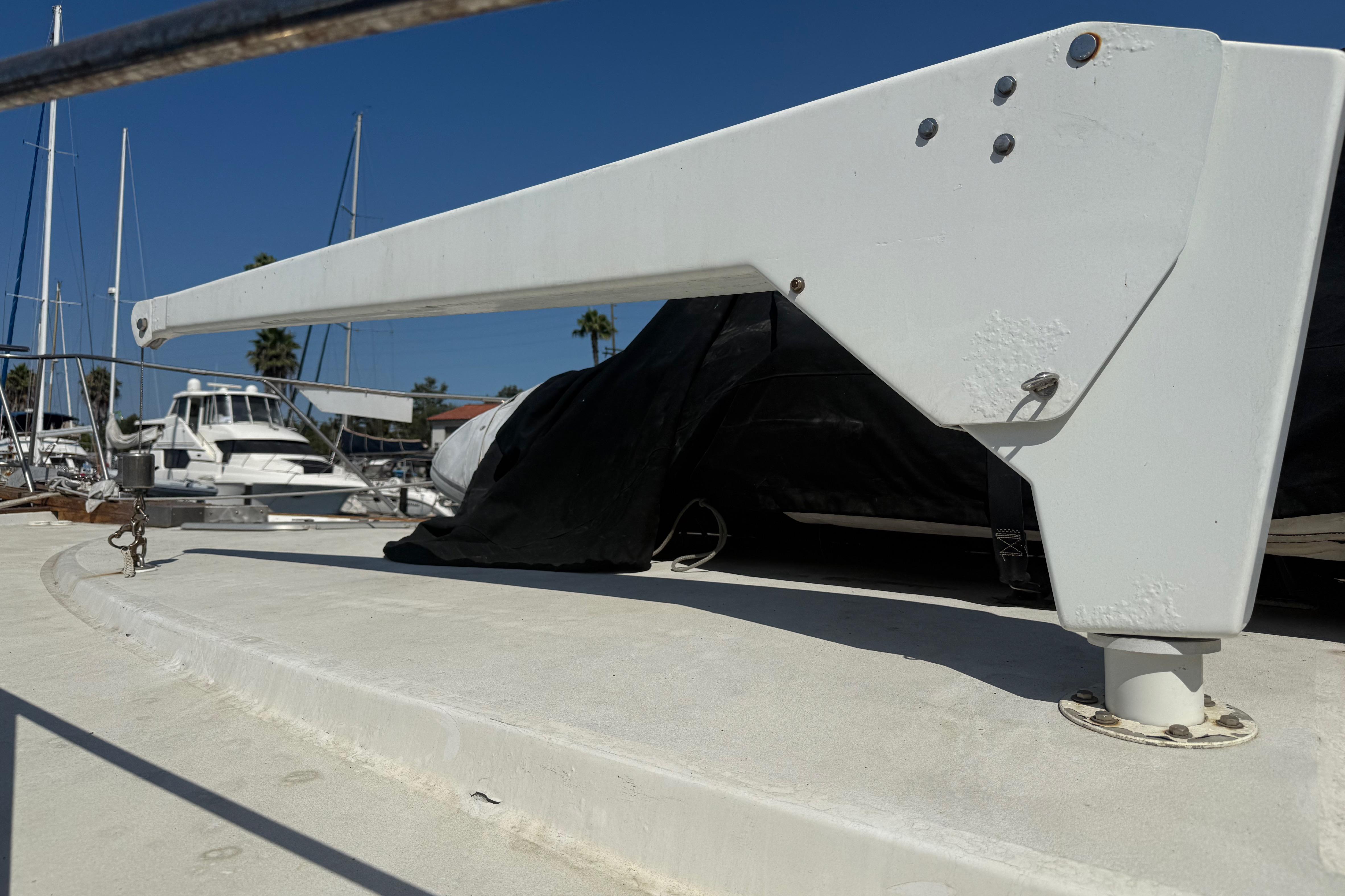 1974 Pacemaker 48 Sportfisherman yacht deck with davit, marina background.