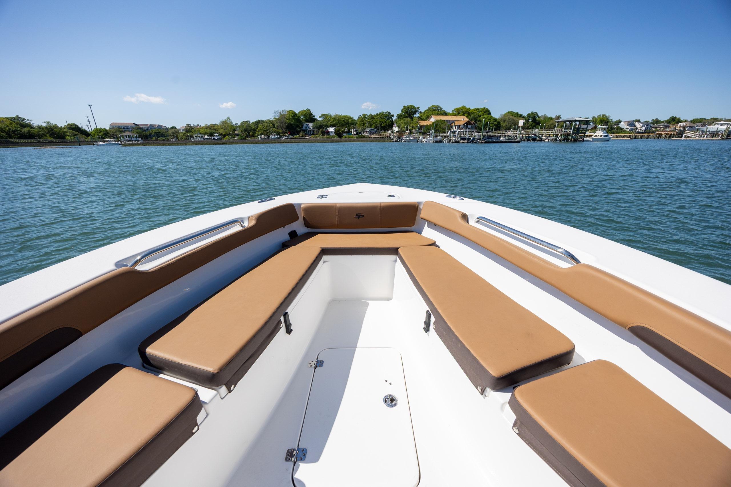 2025 Sea Pro 202 Center Console boat with tan seating, cruising on a calm lake.