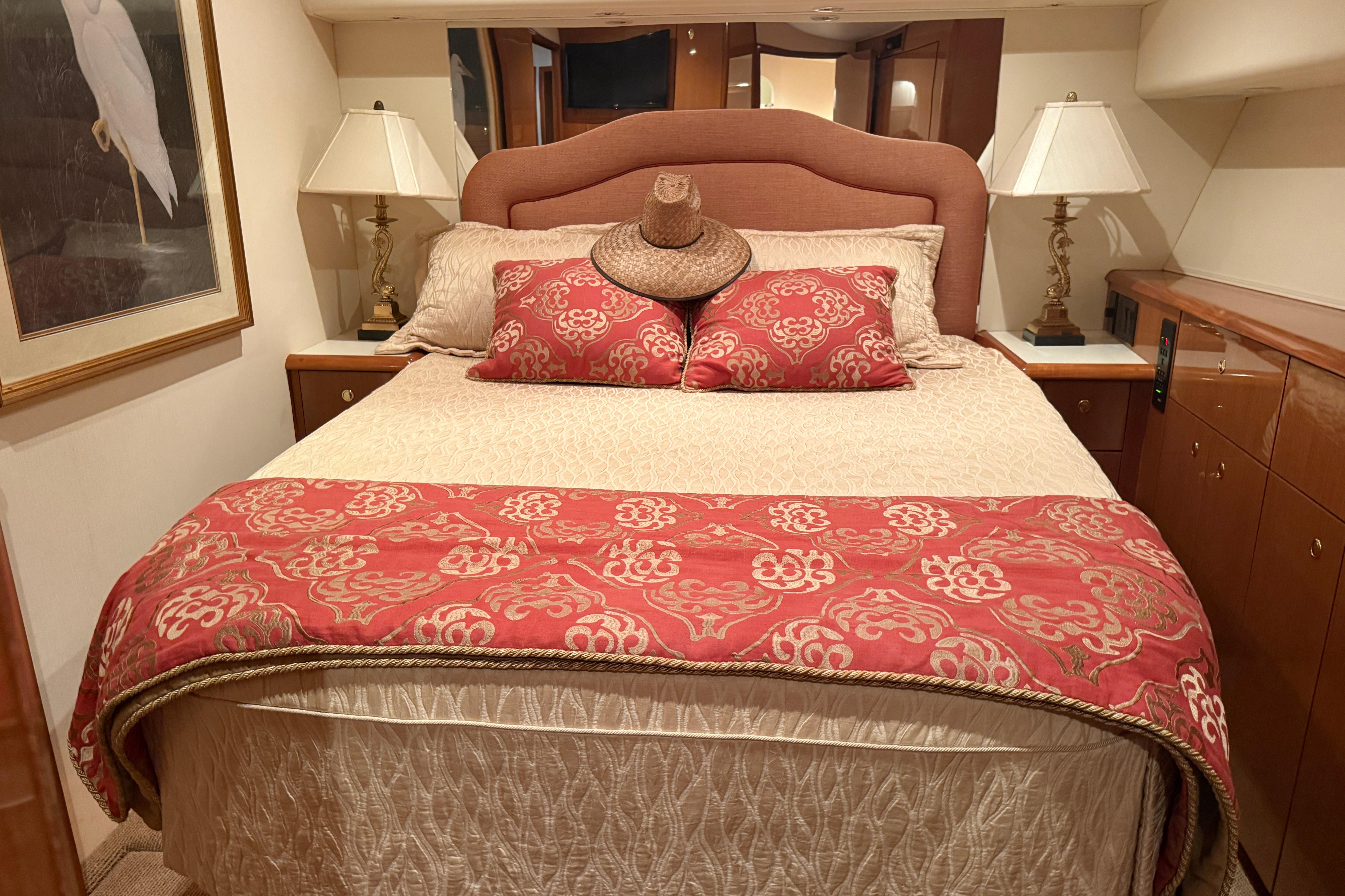 Luxurious bedroom interior of 2000 Viking 55 Convertible yacht with elegant decor and lighting.