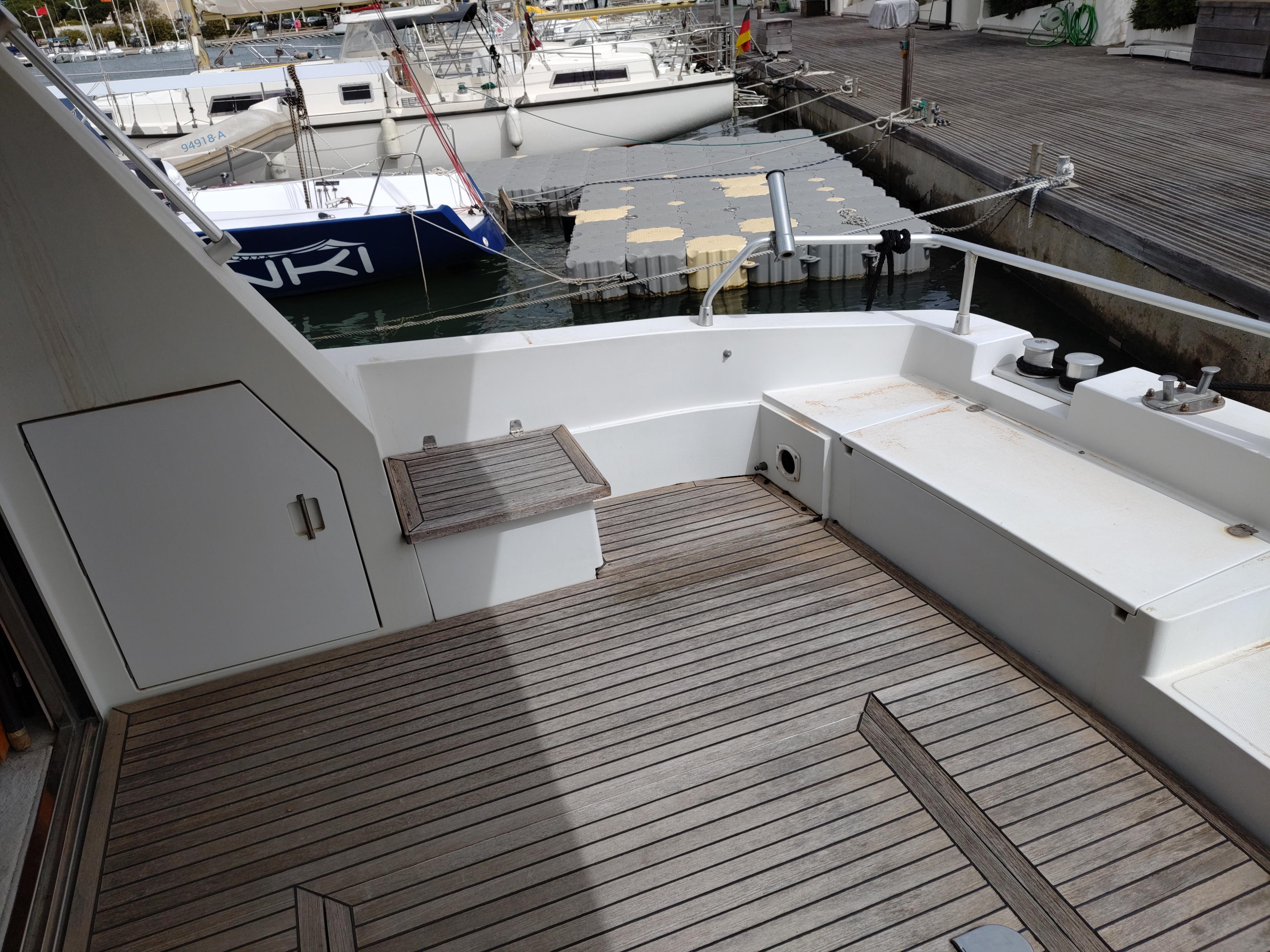 Raffaelli Storm S 1993 yacht deck with wooden flooring, docked at a marina.
