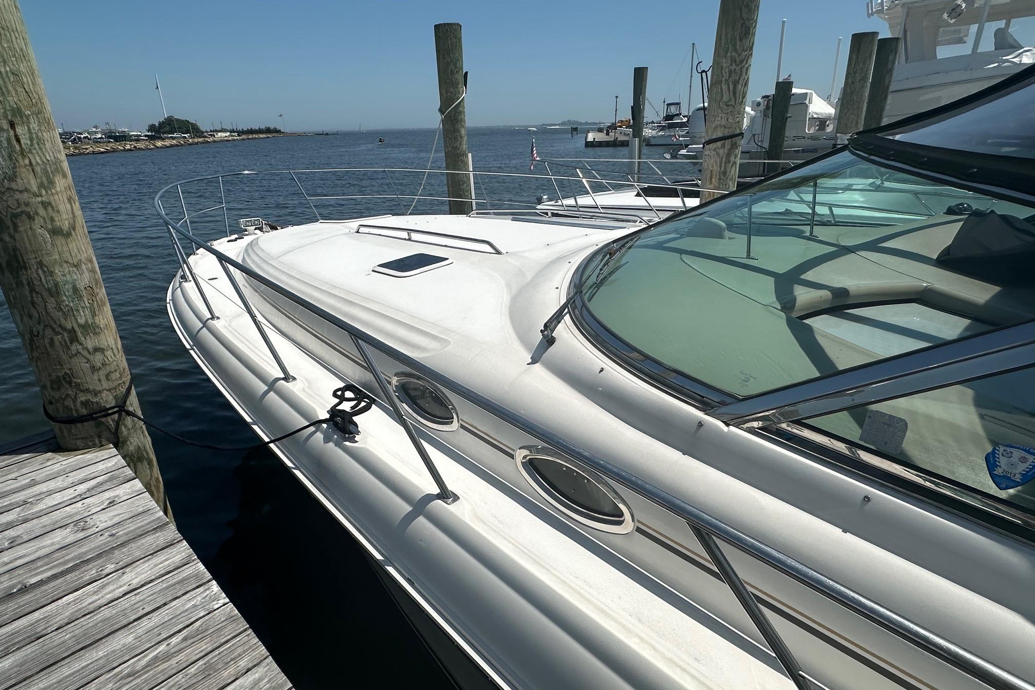 2001 Sea Ray 410 Sundancer yacht docked at a marina on a sunny day.