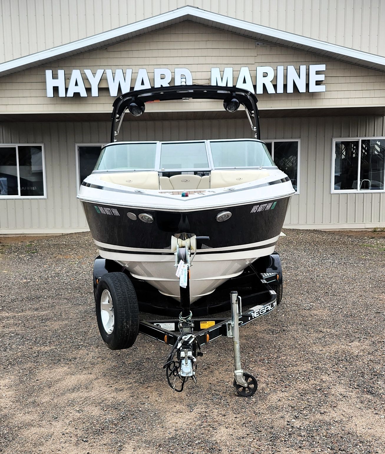 A black and white boat on a trailer in front of a building labeled "HAYWARD MARINE."