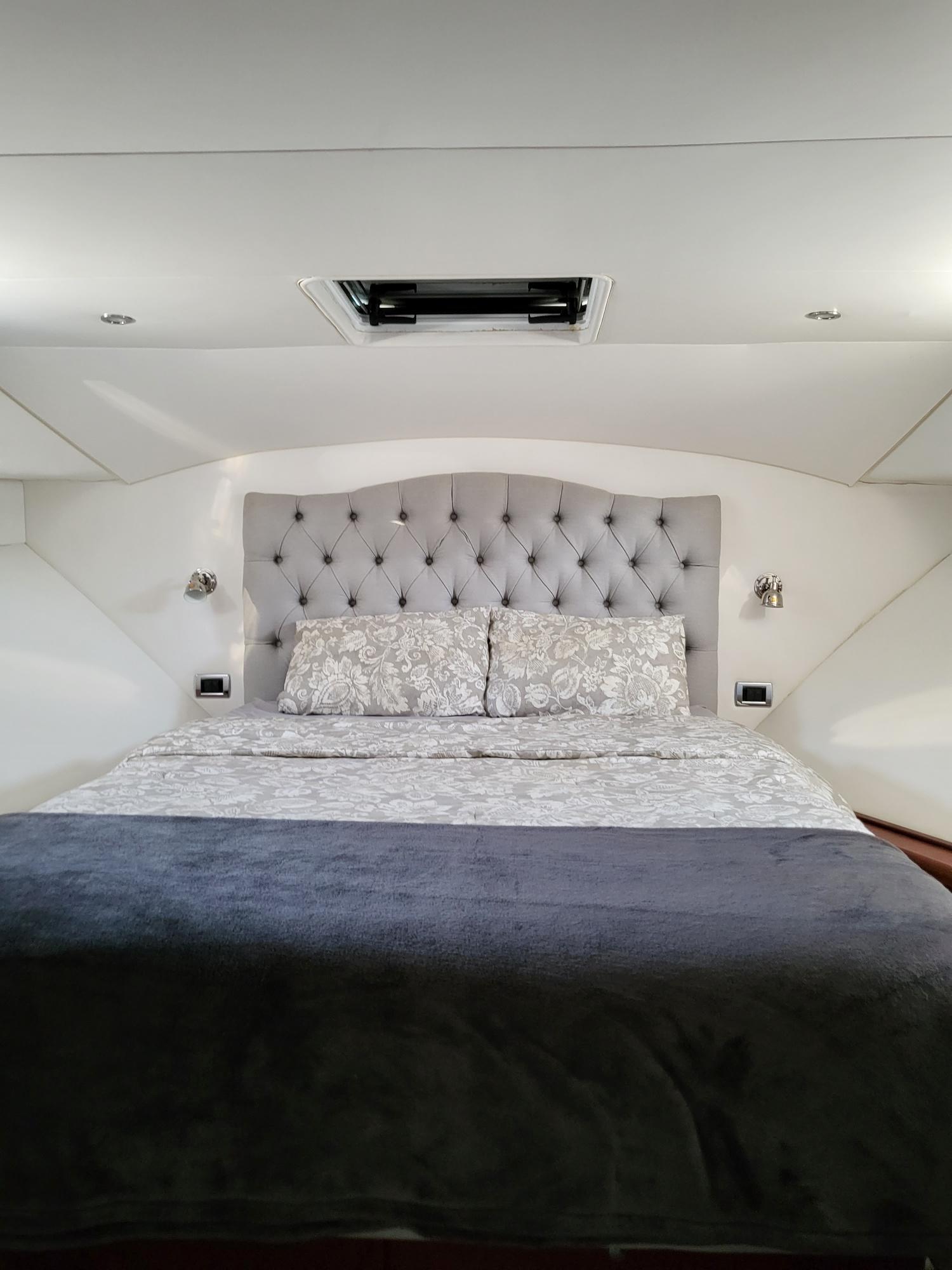 Luxurious bedroom in 2005 Pacific Mariner 65 SE Motoryacht with tufted headboard.