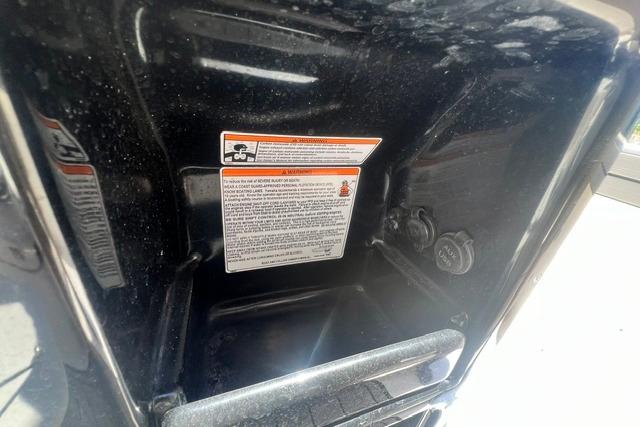 Interior compartment of a 2019 Yamaha Boats 190 FSH Sport with safety labels.