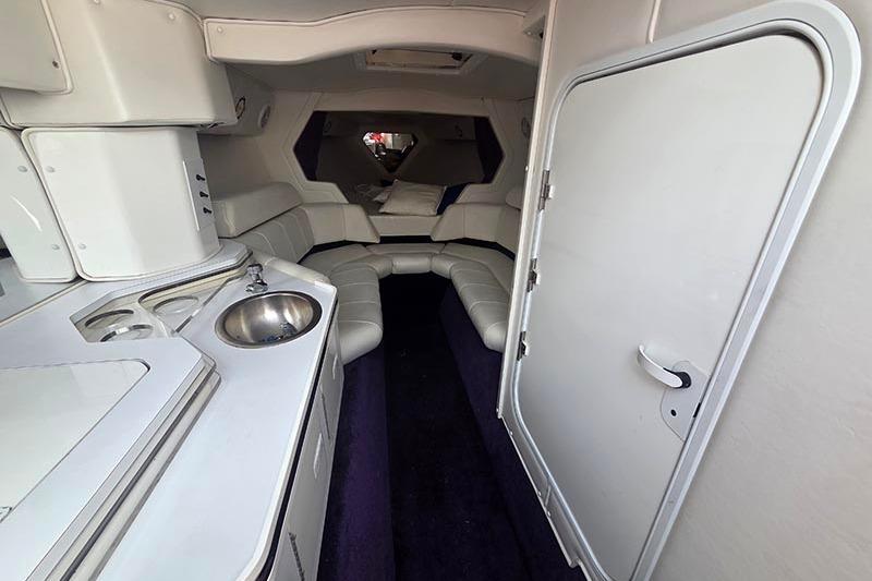 Interior of a 2004 Fountain 38 Lightning boat, featuring a compact kitchenette and seating area.