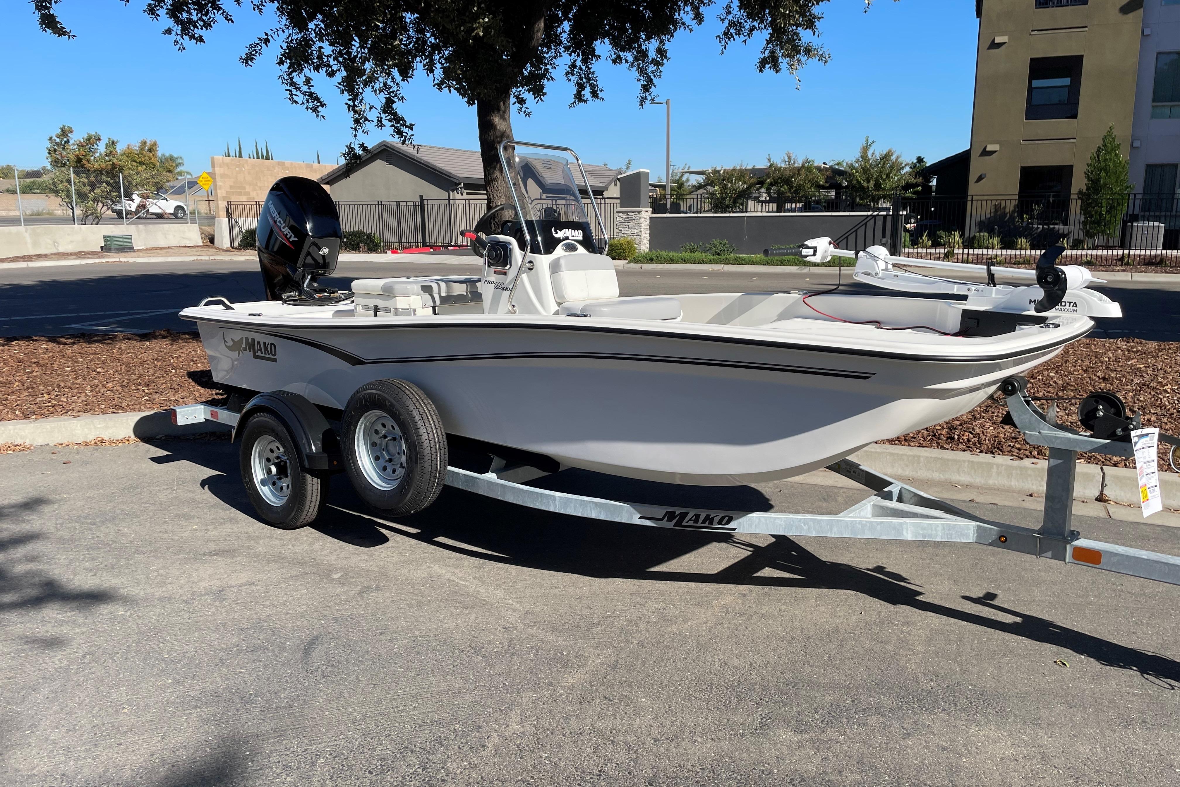 2025 Mako Pro Skiff 15 CC boat on trailer, parked outdoors.