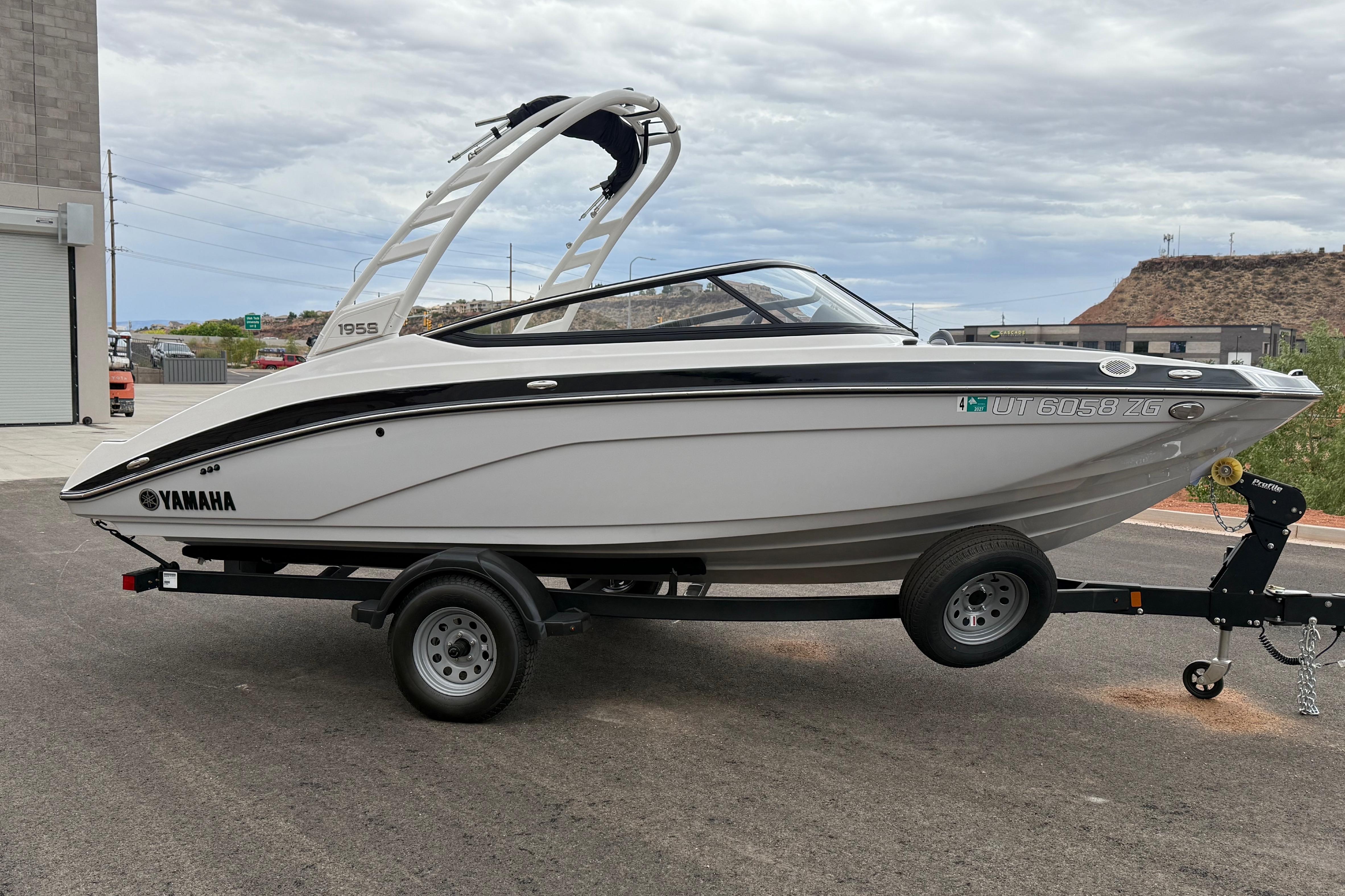 2025 Yamaha Boats 195S on trailer, sleek design, parked outdoors under cloudy sky.