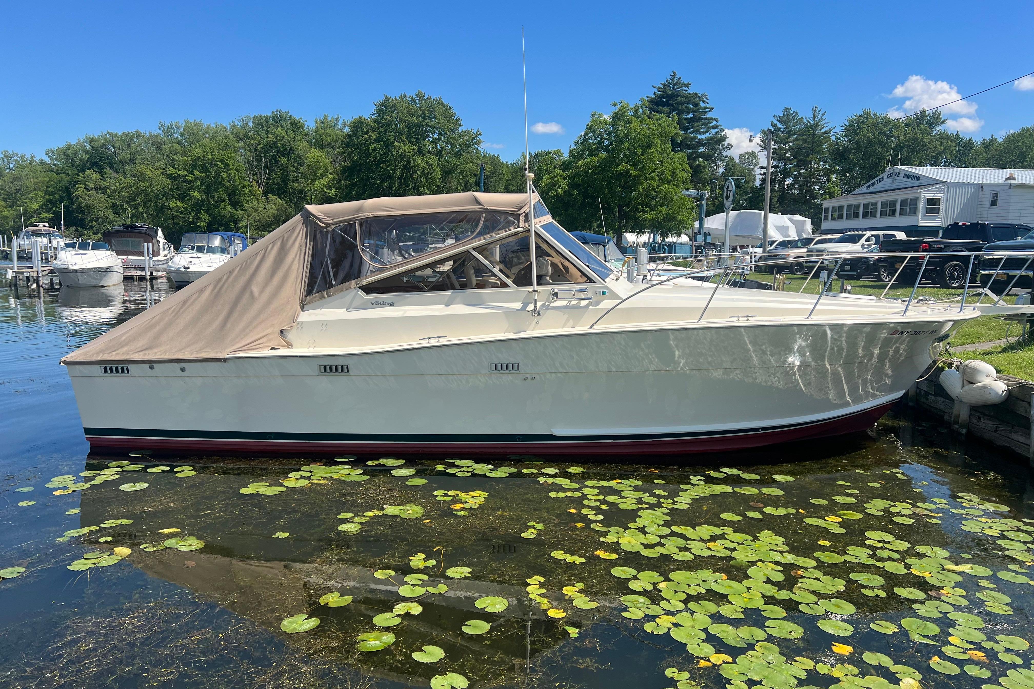 1985 Viking 35 Express boat docked on a sunny day, surrounded by lily pads.