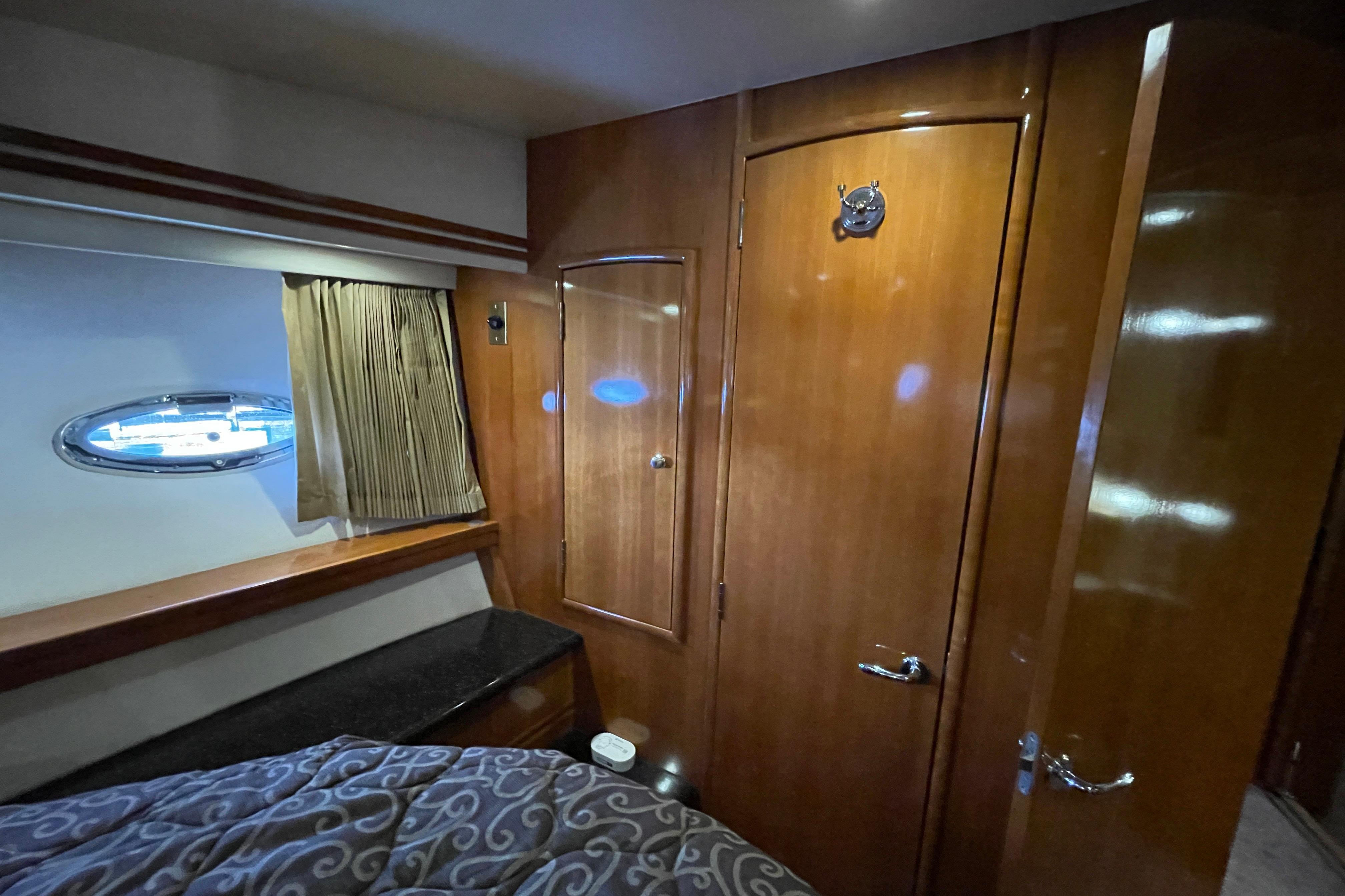 Interior of 2002 Carver 570 Voyager Pilothouse with wood paneling and porthole window.