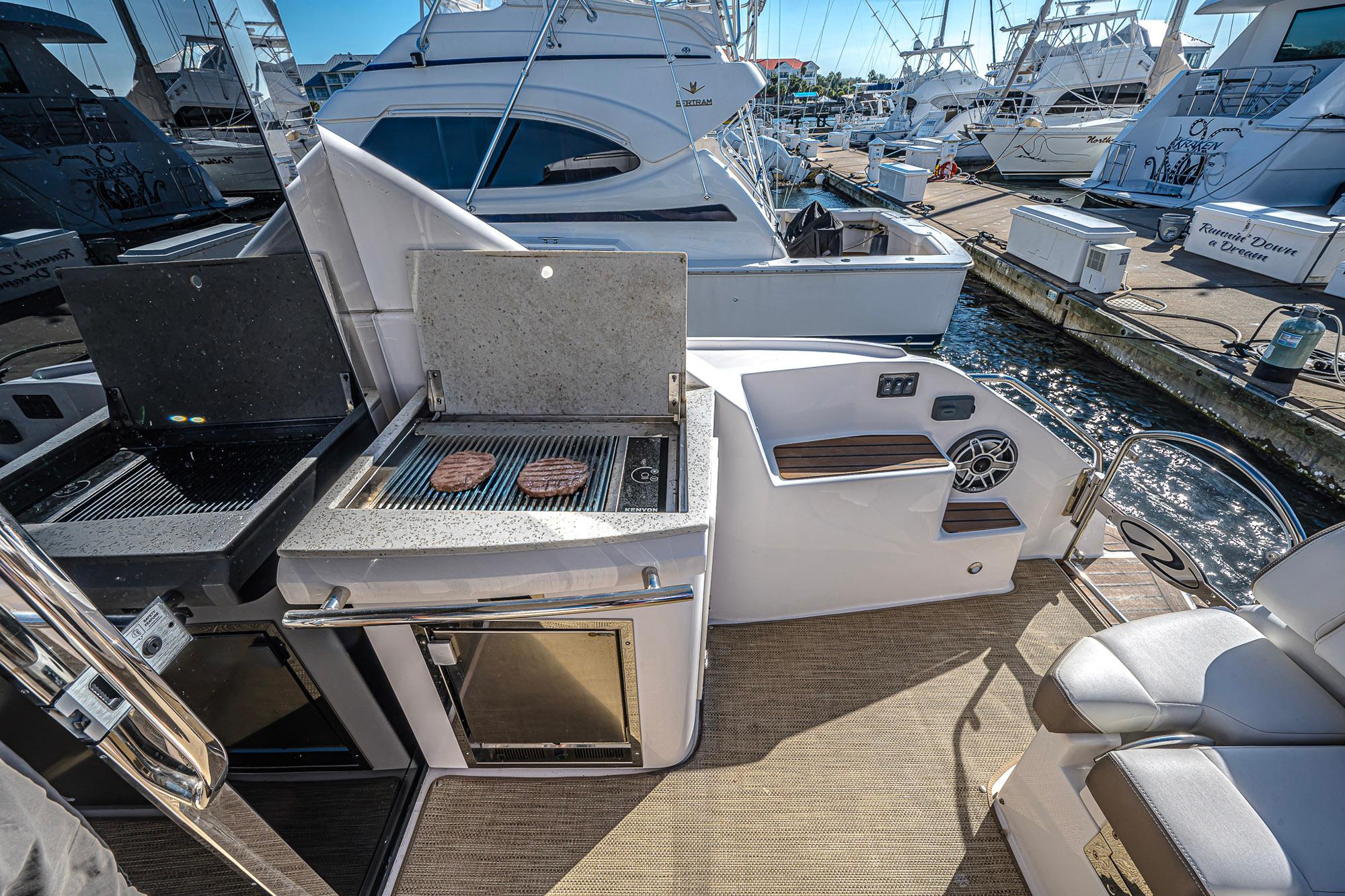 Outdoor grill on 2016 Regal 46 Sport Coupe yacht, docked at marina.