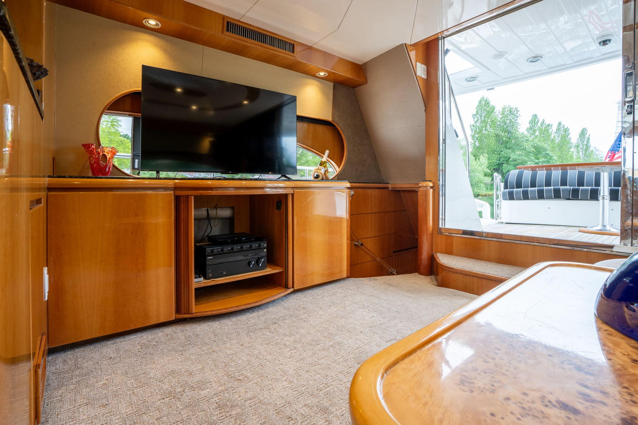 Luxurious interior of 1999 Vitech 68' Pilothouse yacht with TV and elegant wood finish.