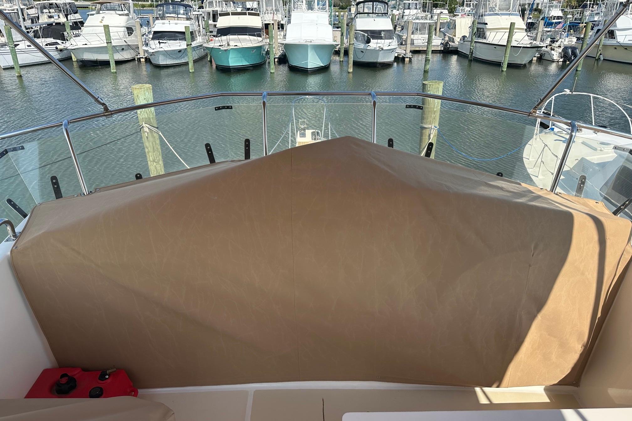 Covered helm station on a 1999 Grand Banks 42 Europa yacht, docked at a marina.