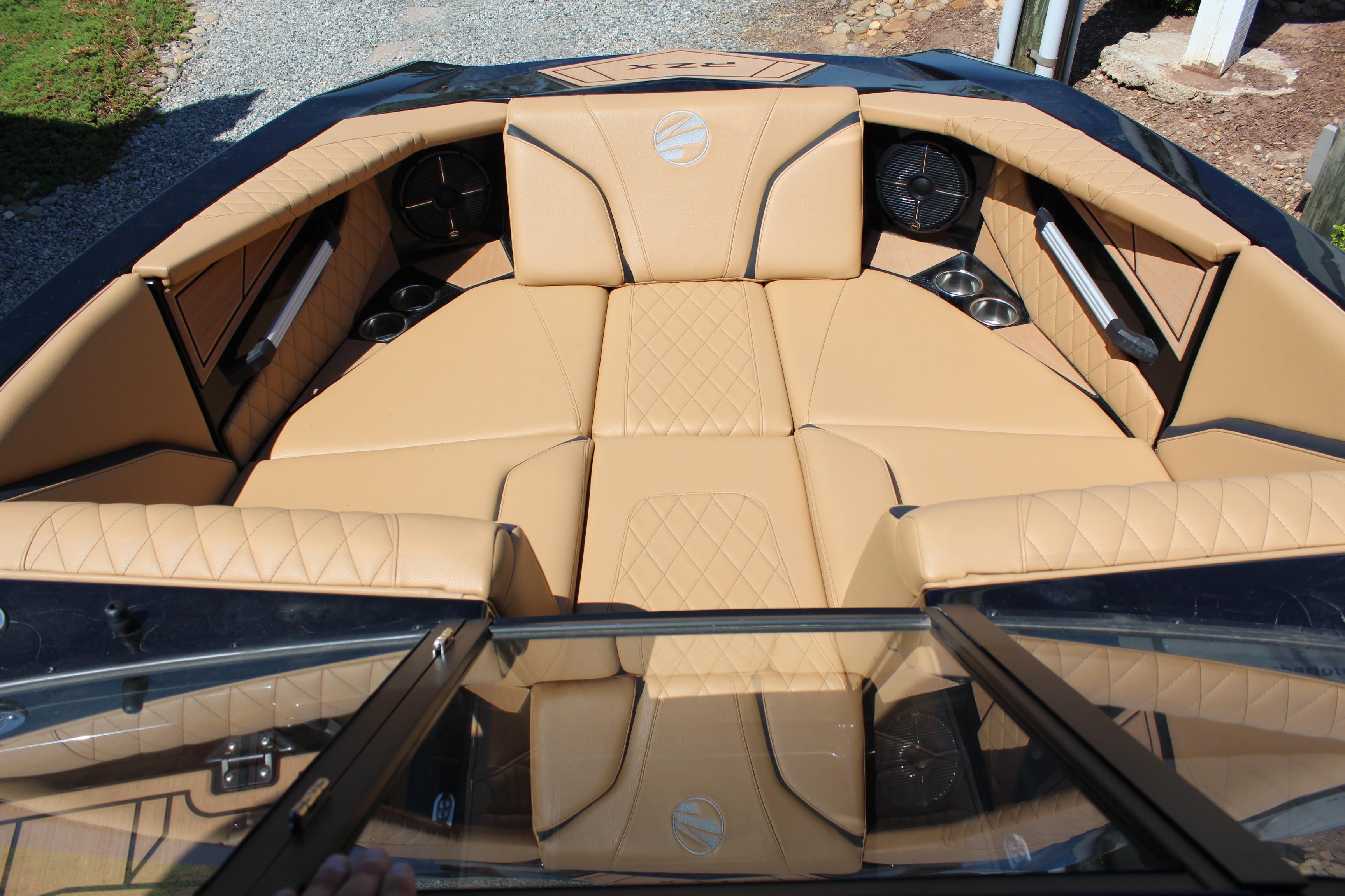 Luxurious interior of 2022 Tigé 22RZX boat with tan upholstery and cup holders.