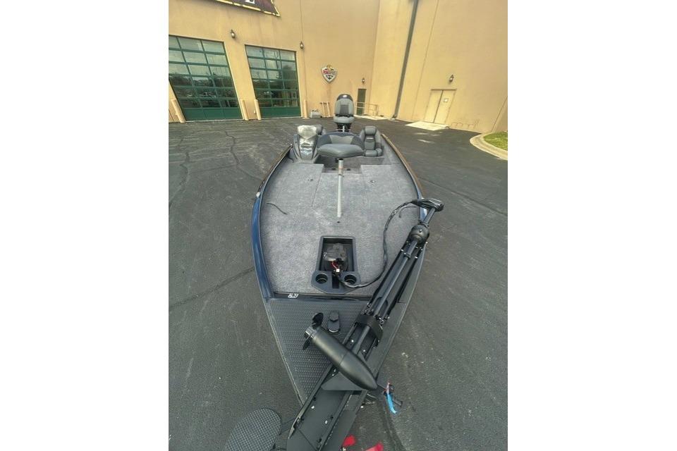 2026 Tracker Savage 215 boat parked outside a building, showcasing its deck and seating.