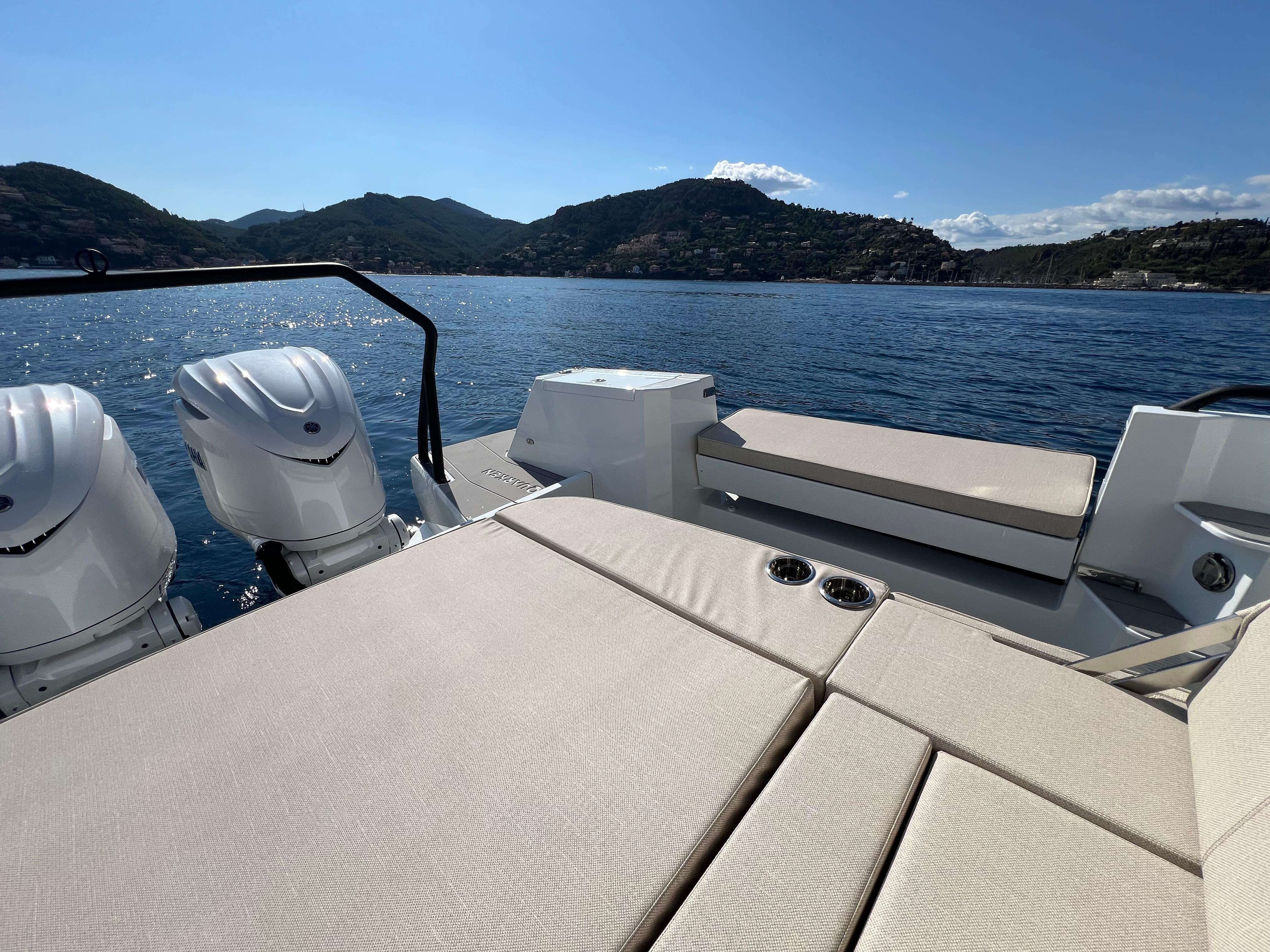 2025 Quarken 35 Sport Tourer on serene water with scenic mountain backdrop.
