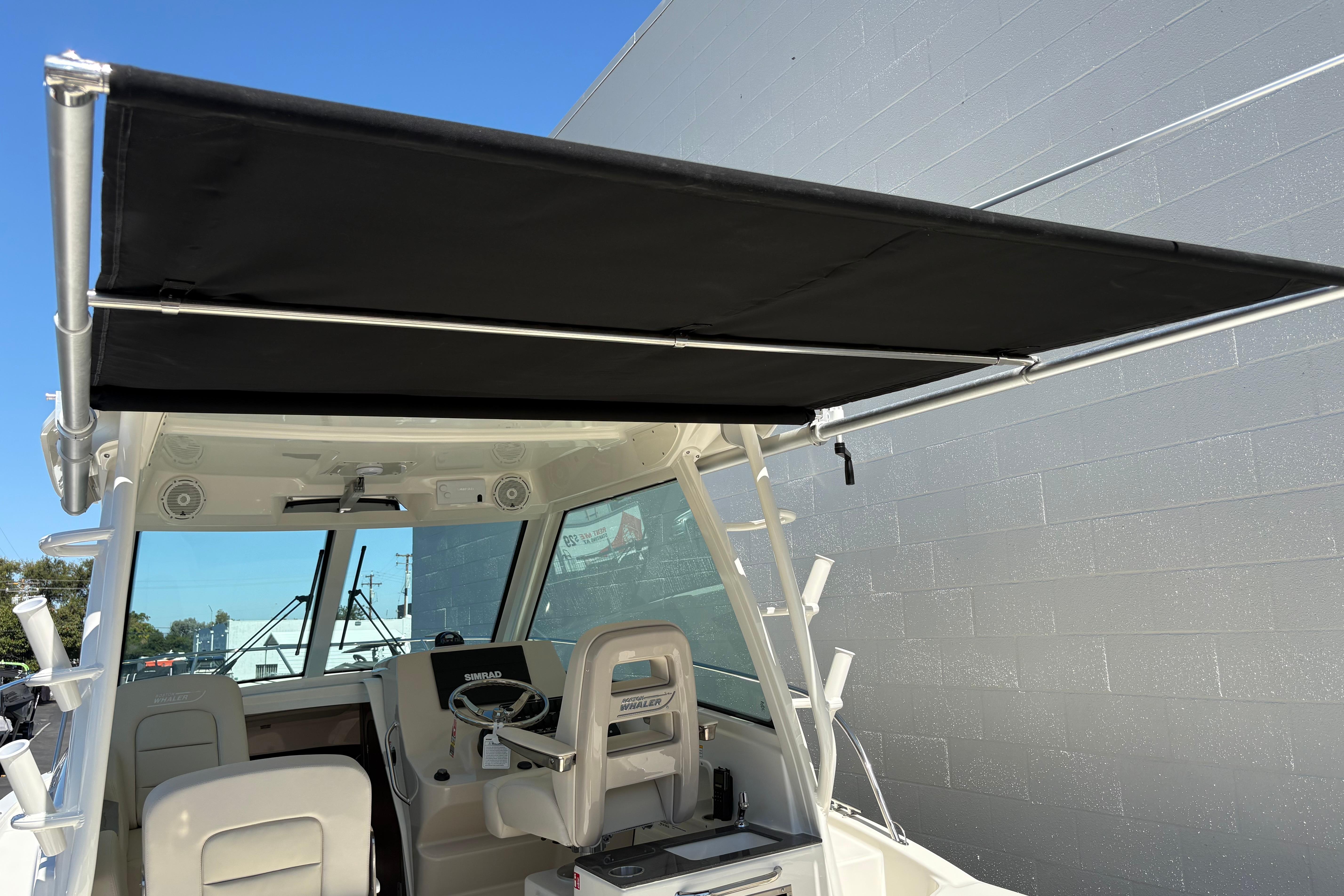 2026 Boston Whaler 285 Conquest boat with black canopy and modern cockpit design.