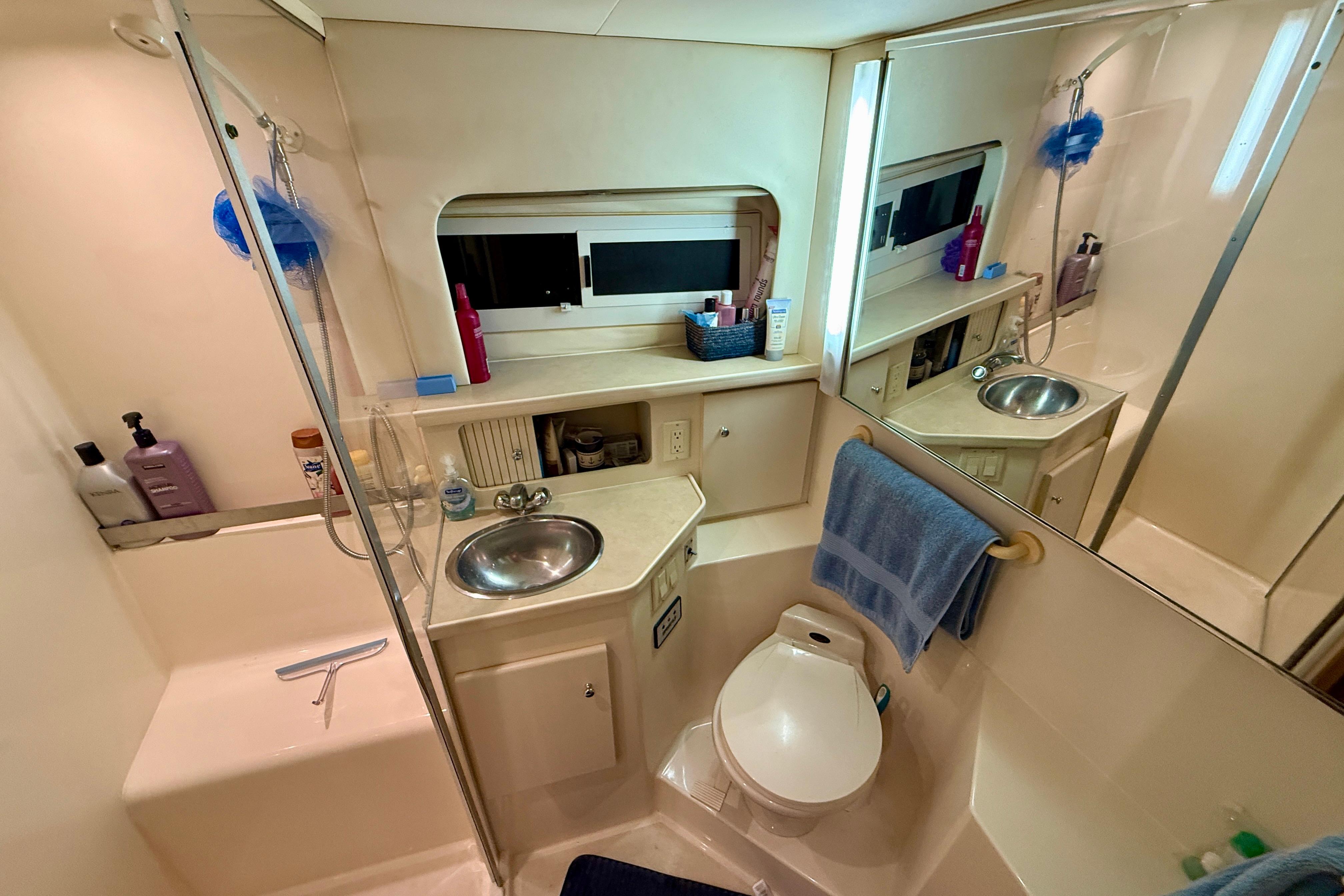 Bathroom of 1997 Carver 355 Aft Cabin Motor Yacht with sink, toilet, and shower.