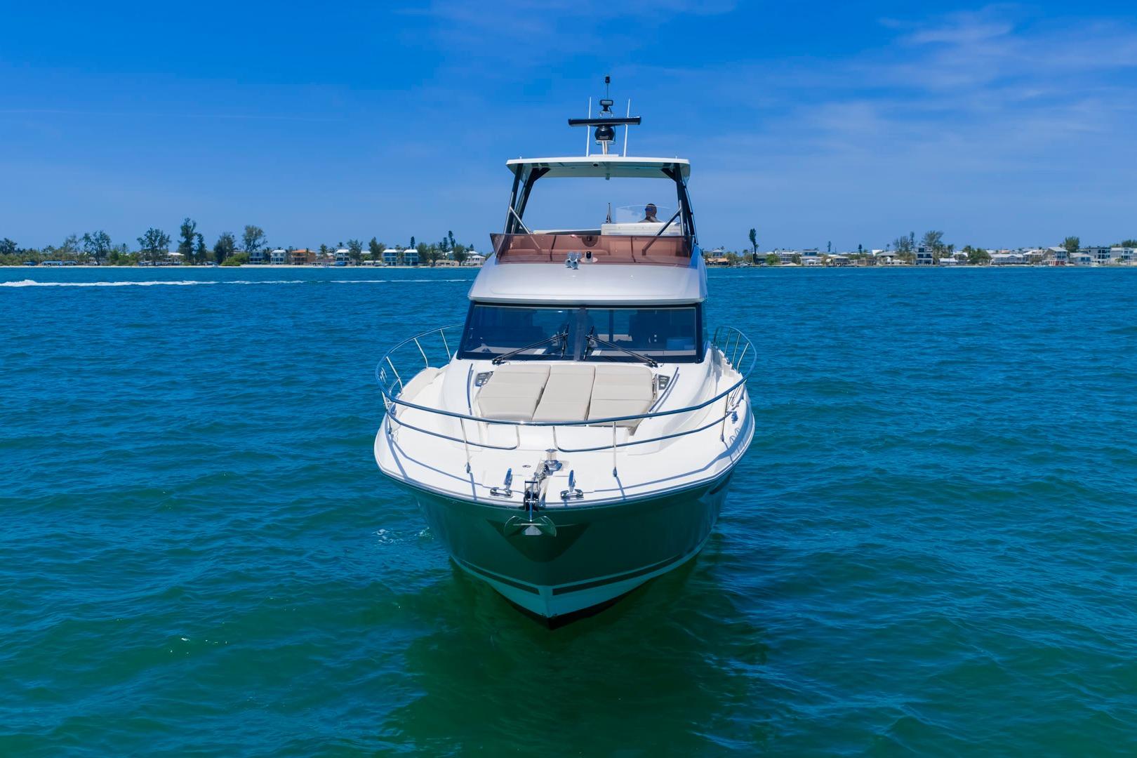 2022 Prestige 520 yacht cruising on clear blue waters under a sunny sky.