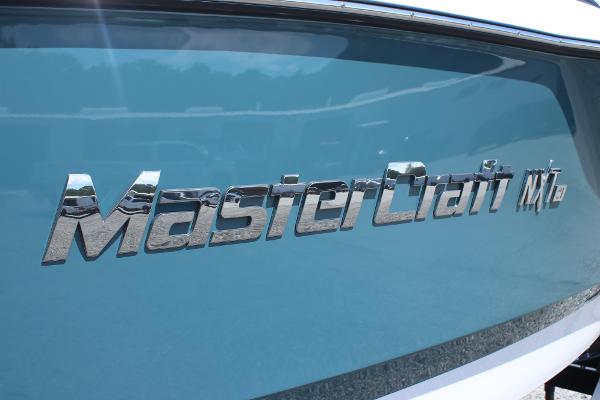 2025 MasterCraft NXT21 boat with sleek blue exterior and chrome logo.