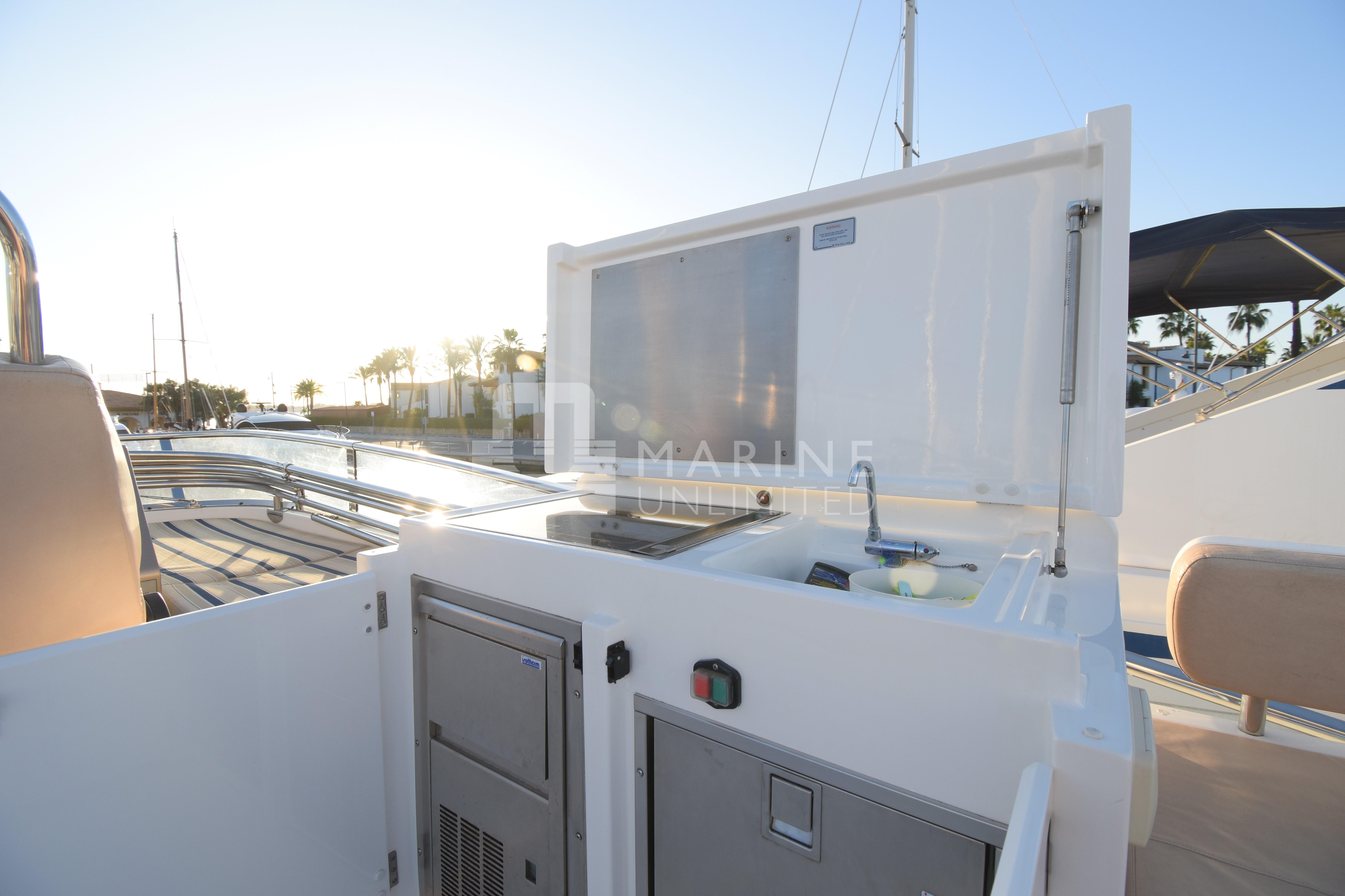 Outdoor kitchenette on 2010 Fairline Squadron 55 yacht, featuring sink and storage.