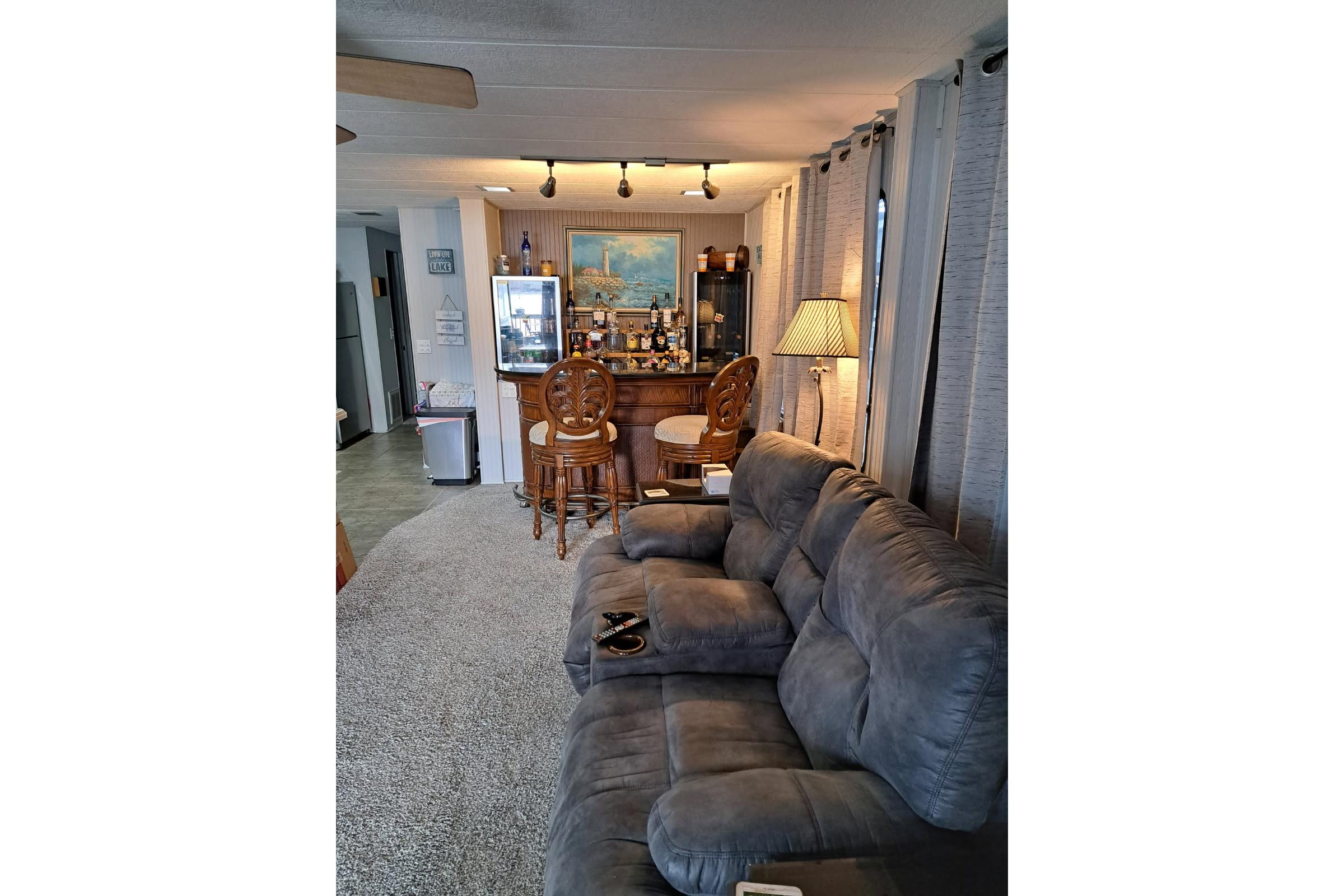 Cozy living area in a 1990 Sumerset 16 x 70 houseboat with plush seating and a bar.