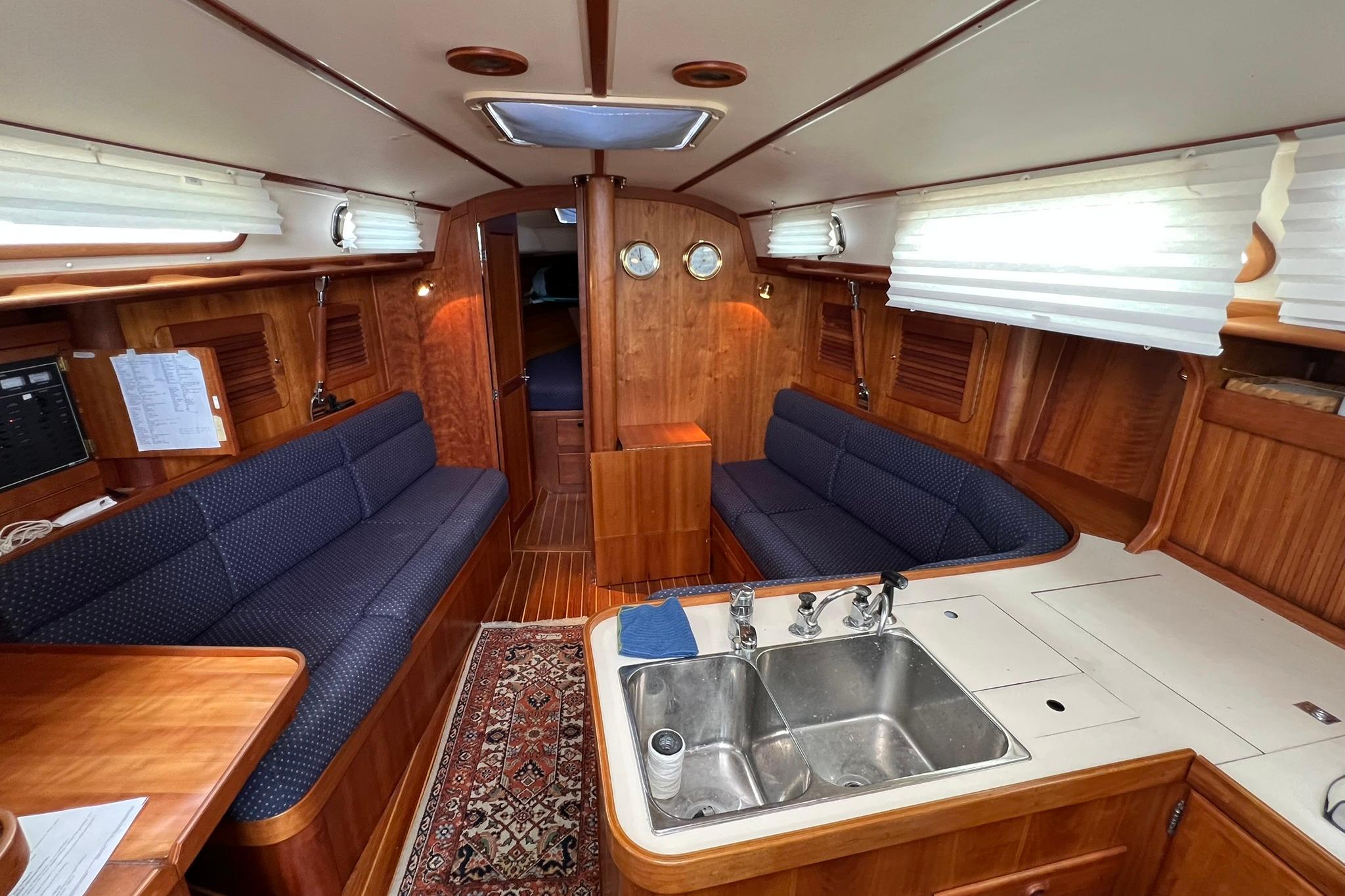 Interior of a 1998 Sabre 362 sailboat with wooden finish and cozy seating.